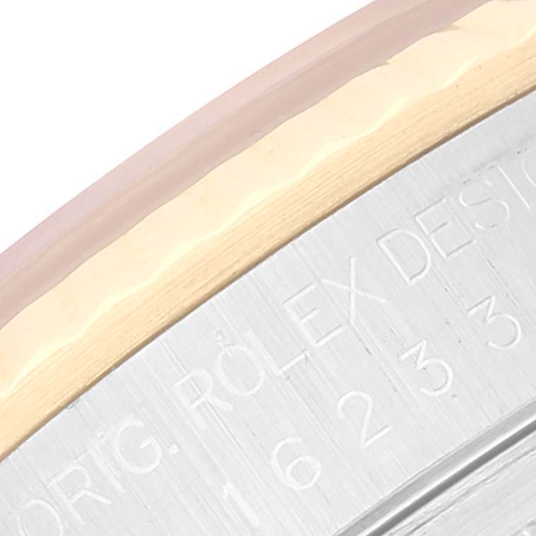 This close-up image of a Rolex Datejust 16233 Men's Steel and Gold (two tone) White Dial 16233 Men's Steel and Gold (two tone) White Dial shows the detailed engraving on the bezel and edge of the watch face.