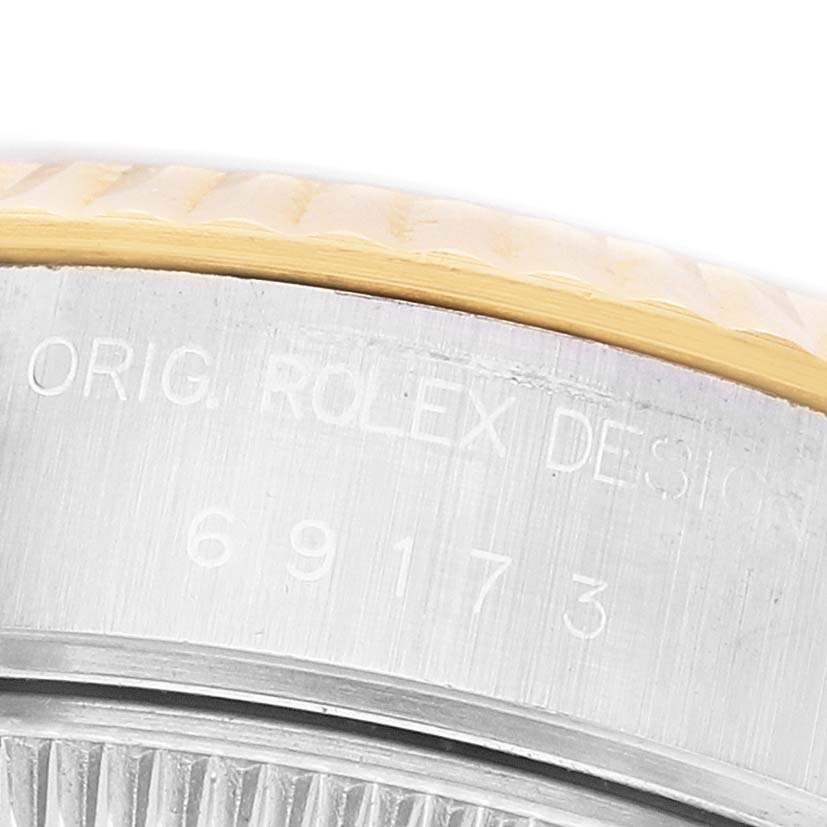 This image shows a close-up of the Rolex Datejust 69173 Women's Steel and Gold (two tone) White Dial's side, highlighting the engraved watch case with the serial number.