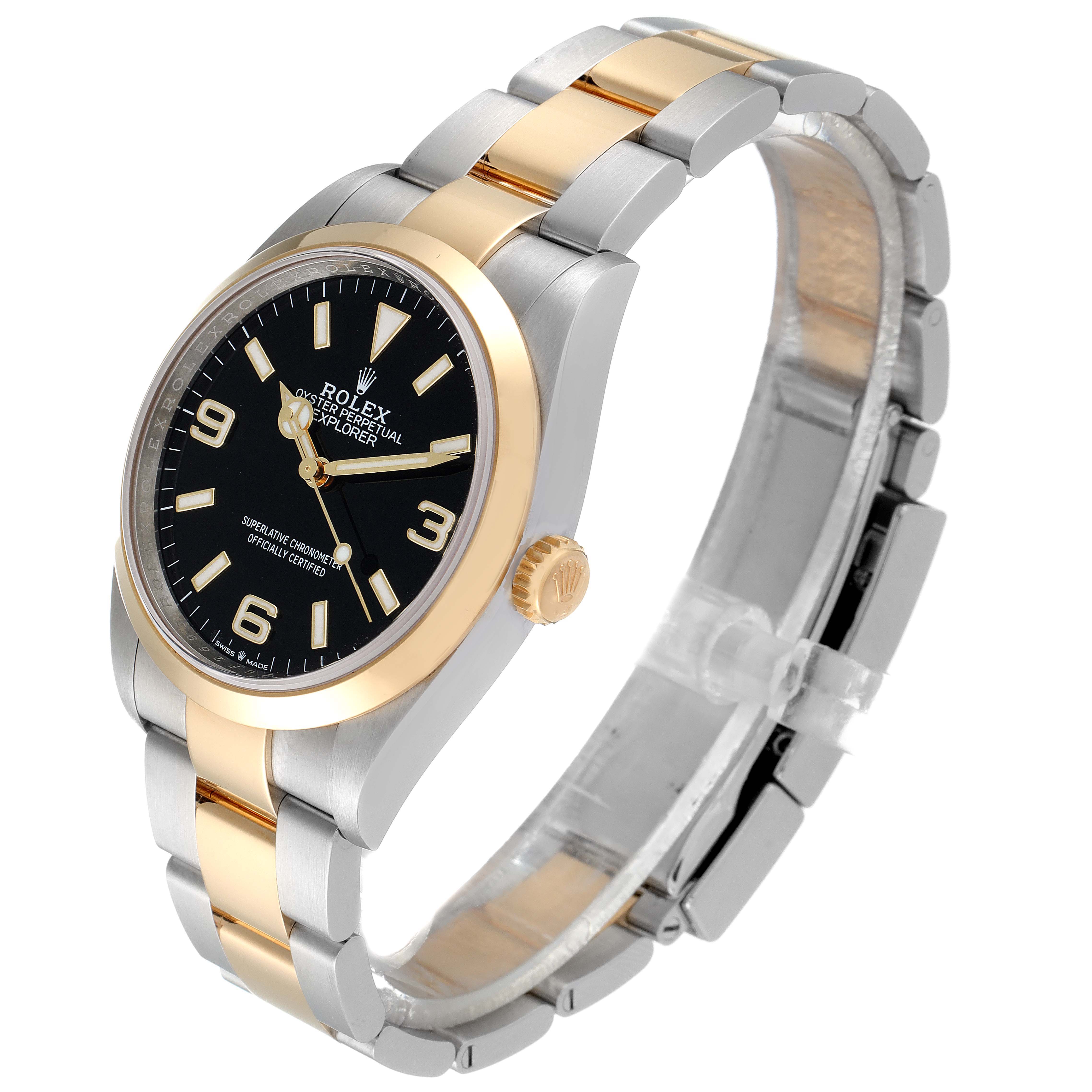 The image shows a Rolex Explorer 124273 Men's Steel and Gold (two tone) Black Dial 124273 Men's Steel and Gold (two tone) Black Dial watch with a side angle, displaying the black dial, gold bezel, and two-tone bracelet.
