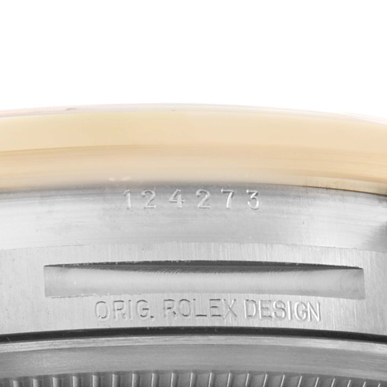 This is a close-up of the engraved serial number and "ORIG. ROLEX DESIGN" inscription on the side of the Rolex Explorer 124273 Men's Steel and Gold (two tone) Black Dial 124273 Men's Steel and Gold (two tone) Black Dial watch case.