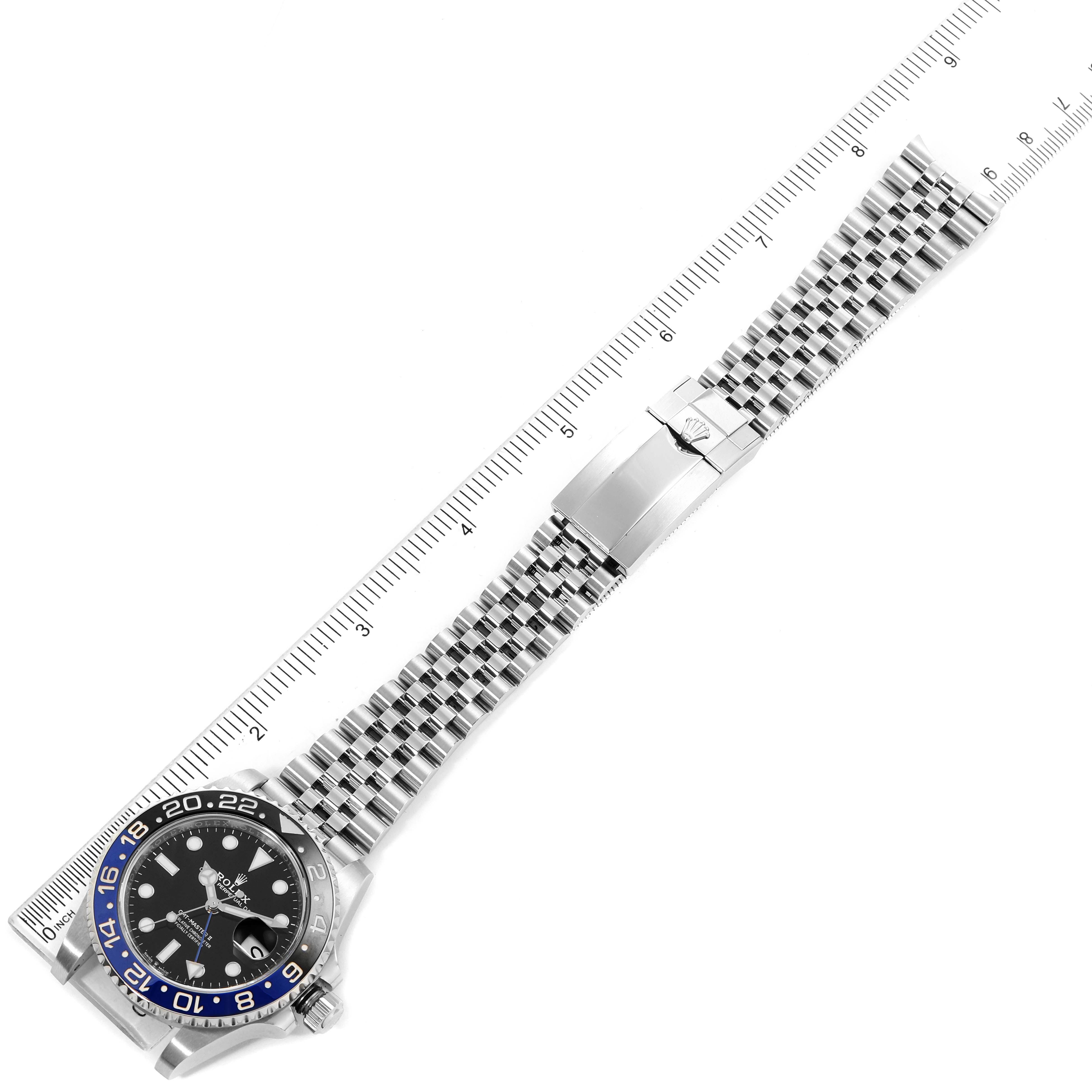 The image shows a top-down view of a Rolex GMT-Master 126710 Men
s Stainless Steel Black Dial 126710 Men
s Stainless Steel Black Dial watch with a ruler measuring the length of the watch and its metal bracelet.
