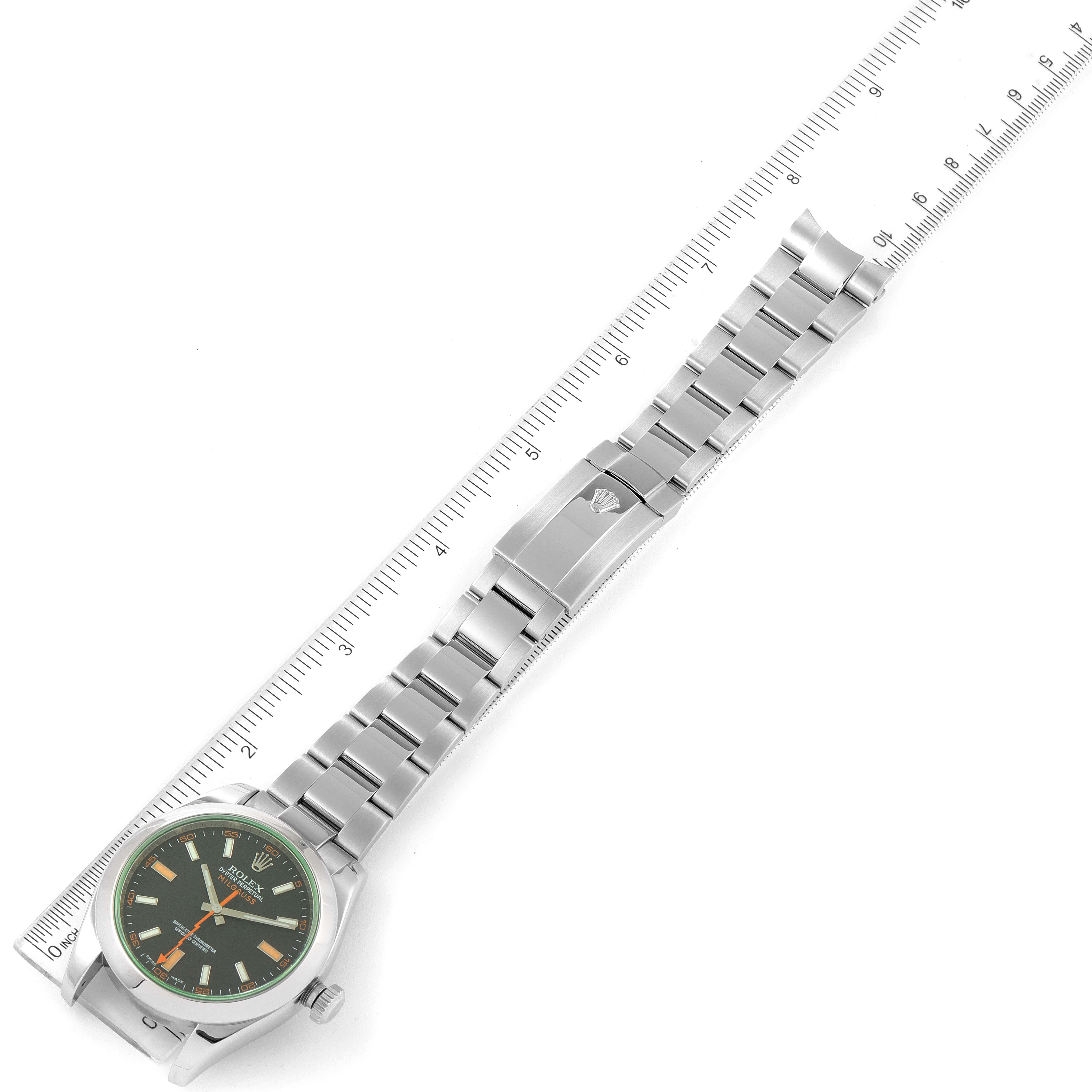 The image shows a Rolex Milgauss 116400V Men
s Stainless Steel Black Dial 116400V Men
s Stainless Steel Black Dial watch laid flat with a ruler alongside it to depict size, highlighting the face and bracelet.