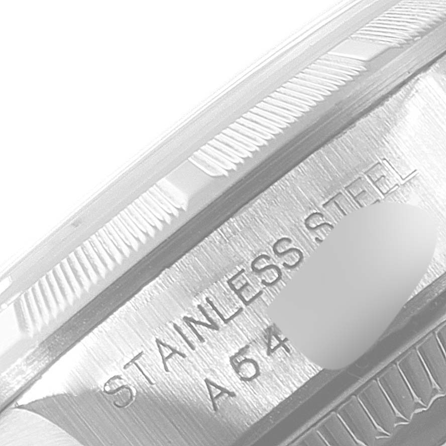 This close-up angle shows the edge and part of the case back of a Rolex Oyster Perpetual 67230 Women's Stainless Steel Black Dial 67230 Women's Stainless Steel Black Dial watch, with "STAINLESS STEEL" engraved.