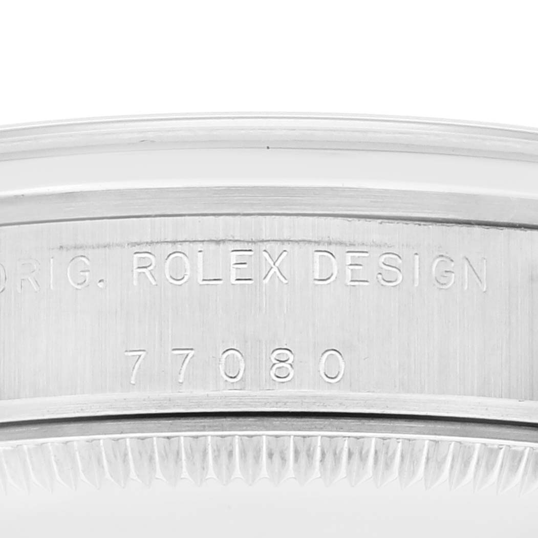 The image shows the engraved side of the bezel for a Rolex Mid-Size 77080 Women
s Stainless Steel Blue Dial 77080 Women
s Stainless Steel Blue Dial model, displaying "ORIG. ROLEX DESIGN" and the model number "77080."