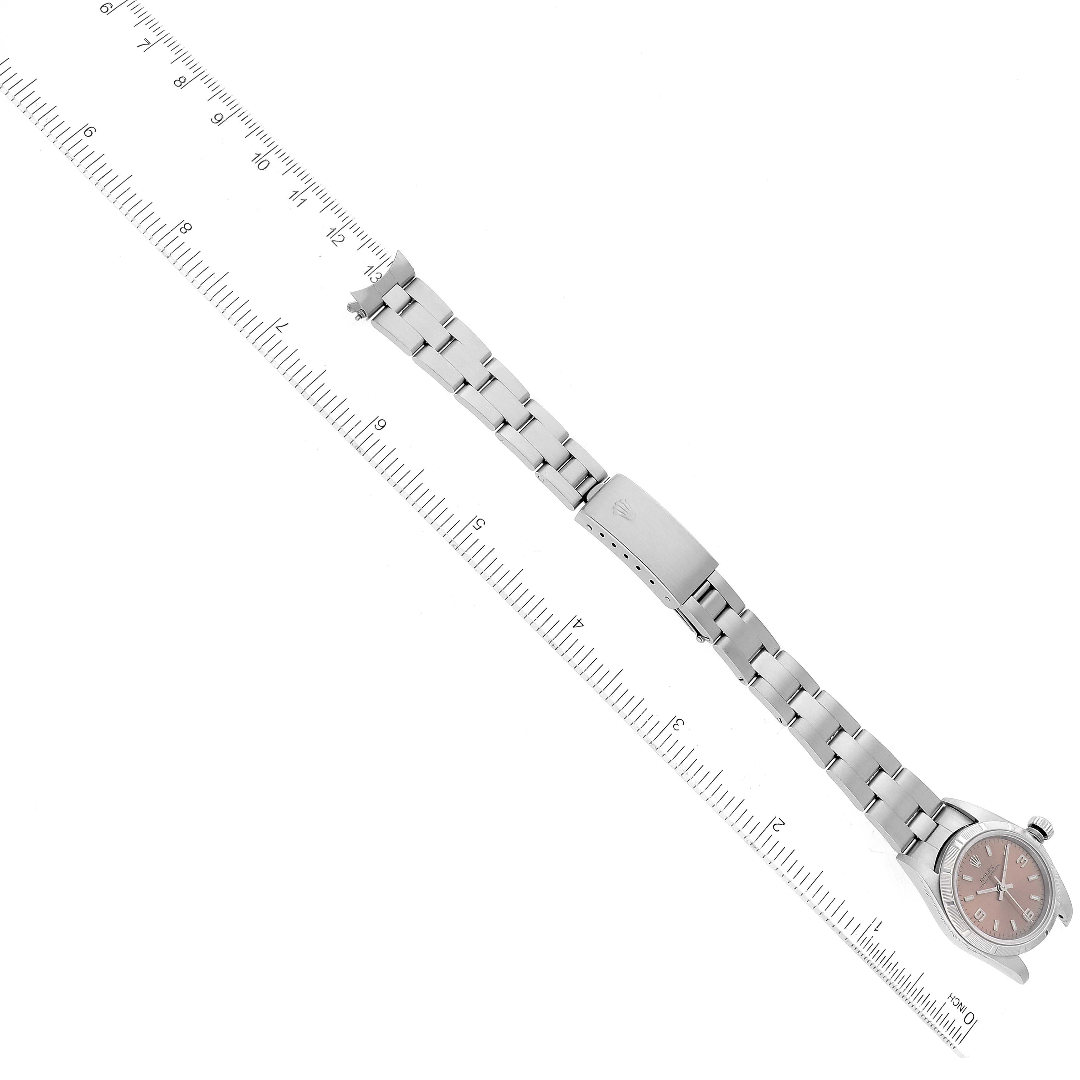 The Rolex Oyster Perpetual 76030 Women's Stainless Steel Pink Dial 76030 Women's Stainless Steel Pink Dial watch is laid flat with a ruler along the bracelet; the watch face and clasp are visible.