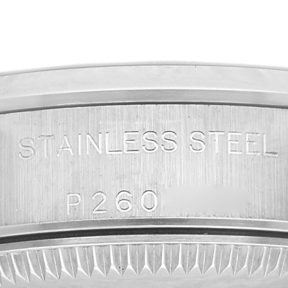 A close-up view of the engraved case back of a Rolex Oyster Perpetual 76080 Women's Stainless Steel Pink Dial 76080 Women's Stainless Steel Pink Dial watch, showing "STAINLESS STEEL" and part of a serial number.