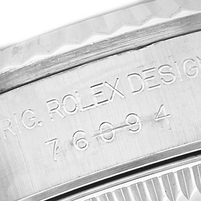 This image shows a close-up of the serial number and engraving on the side of a Rolex Oyster Perpetual 76094 Women's Stainless Steel Blue Dial 76094 Women's Stainless Steel Blue Dial watch case.