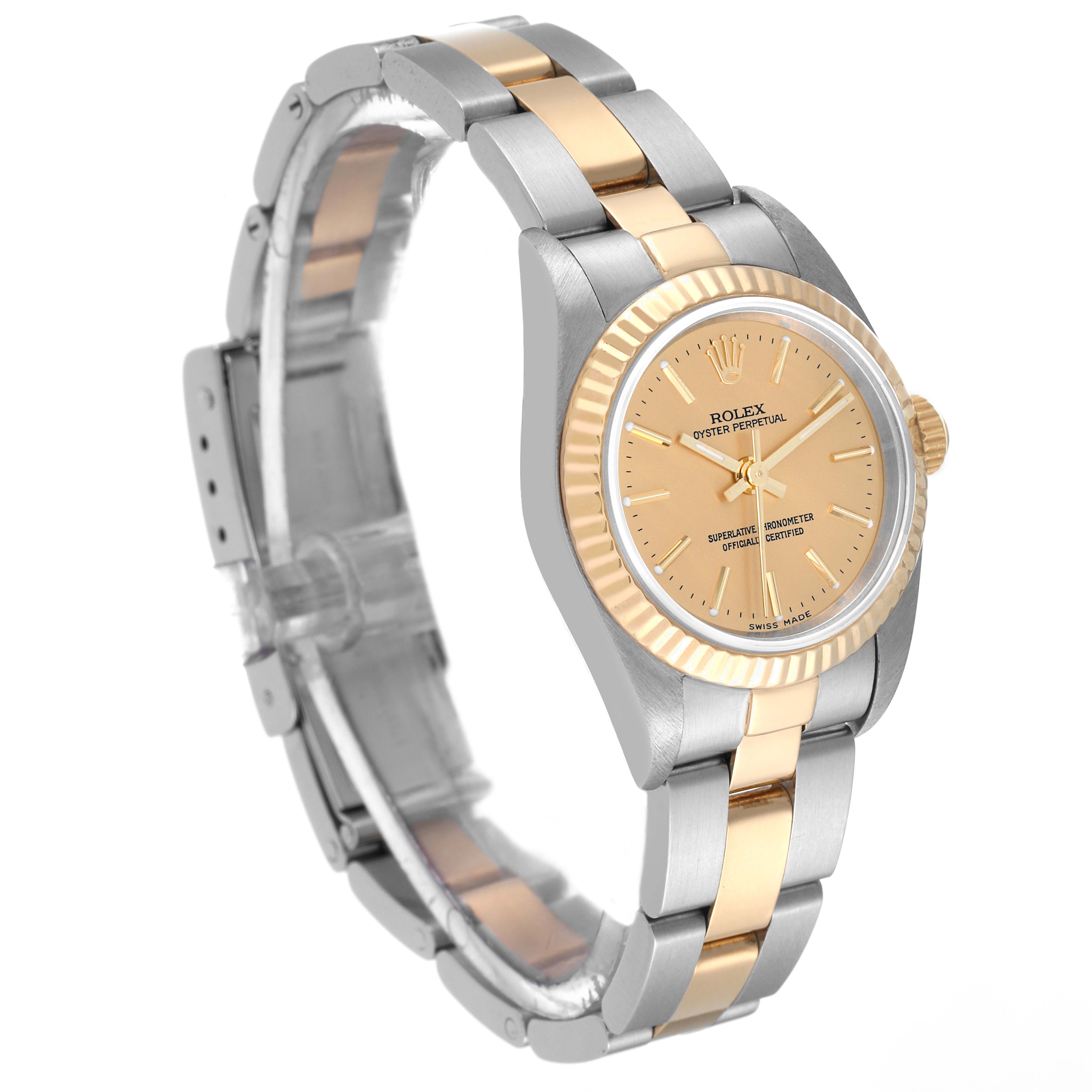 This image shows the Rolex Oyster Perpetual 76193 Women's Steel and Gold (two tone) Champagne Dial 76193 Women's Steel and Gold (two tone) Champagne Dial watch at a 3/4 angle, highlighting its two-tone bracelet, fluted bezel, and champagne dial.
