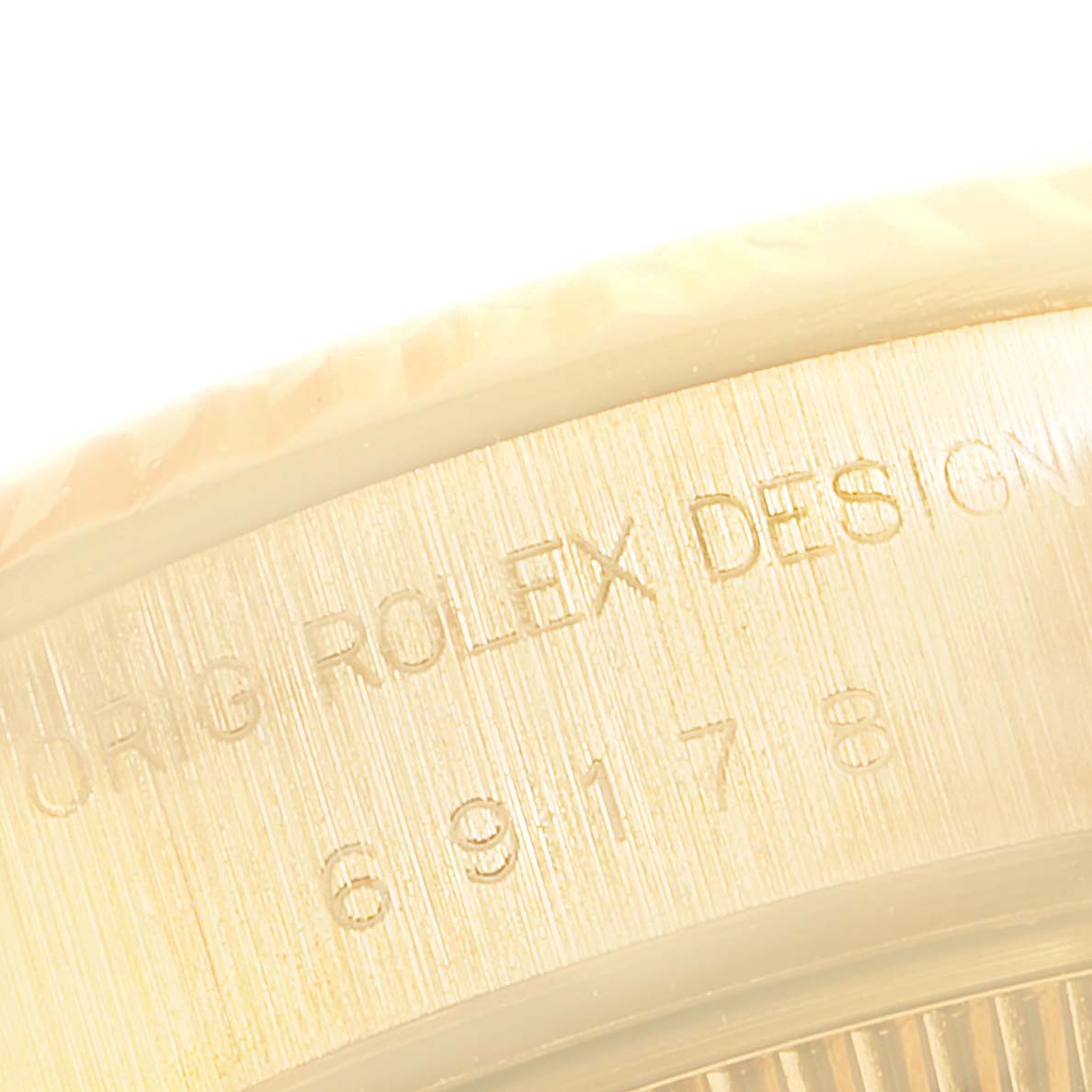 Close-up shot of the case side of a Rolex President 69178 Women
s Yellow Gold Champagne Dial 69178 Women
s Yellow Gold Champagne Dial watch, displaying engraving details.