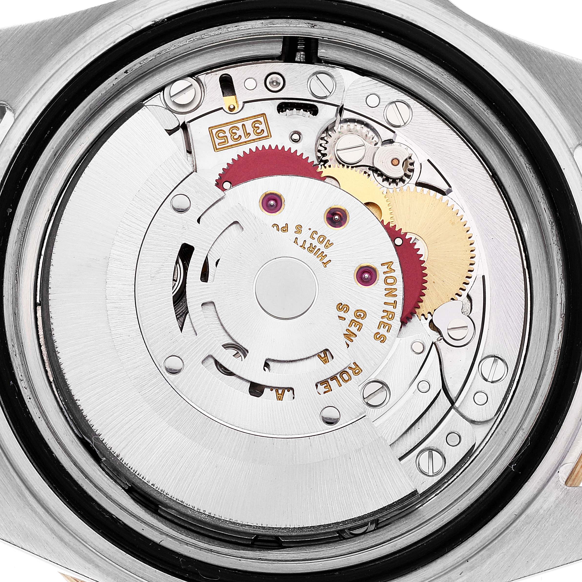 The image shows a close-up of the movement mechanism of a Rolex Submariner 16613 Men's Steel and Gold (two tone) Grey Dial 16613 Men's Steel and Gold (two tone) Grey Dial watch, highlighting its intricate gears and components.