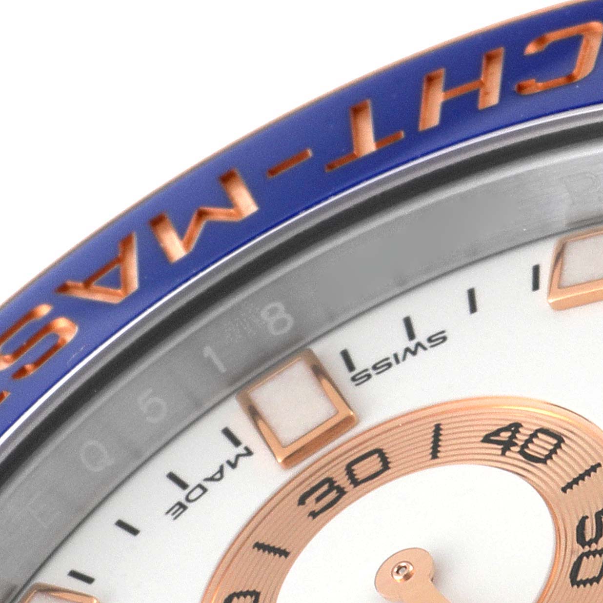 The image shows a close-up of the Rolex Yacht-Master 116681 Men
s Steel and Gold (two tone) White Dial 116681 Men
s Steel and Gold (two tone) White Dial
s bezel, part of its dial, and hour markers.