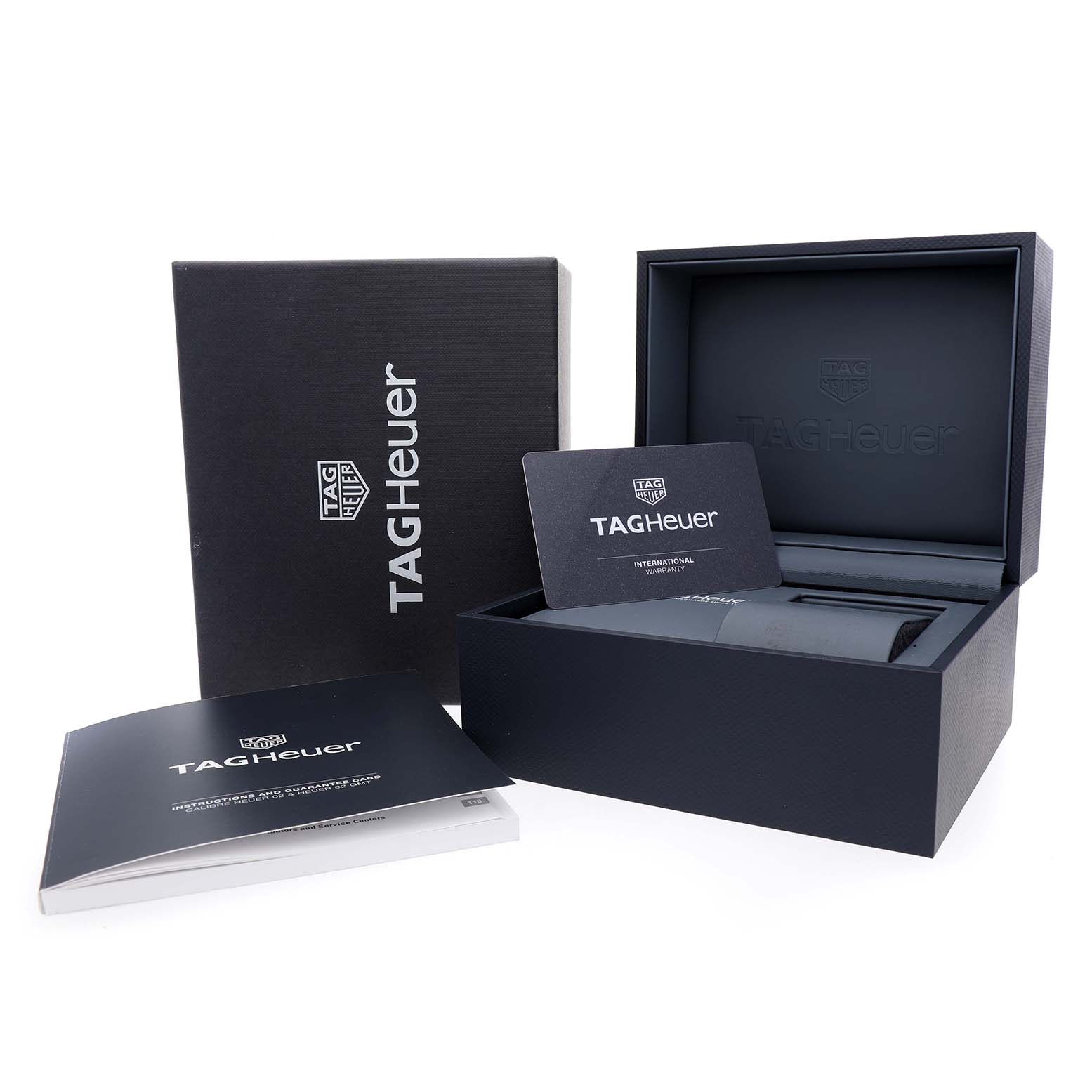 The image shows the packaging and accessories for a Tag Heuer Carrera CBN2011 Men's Stainless Steel Blue Dial watch, including a box, a booklet, and a warranty card.