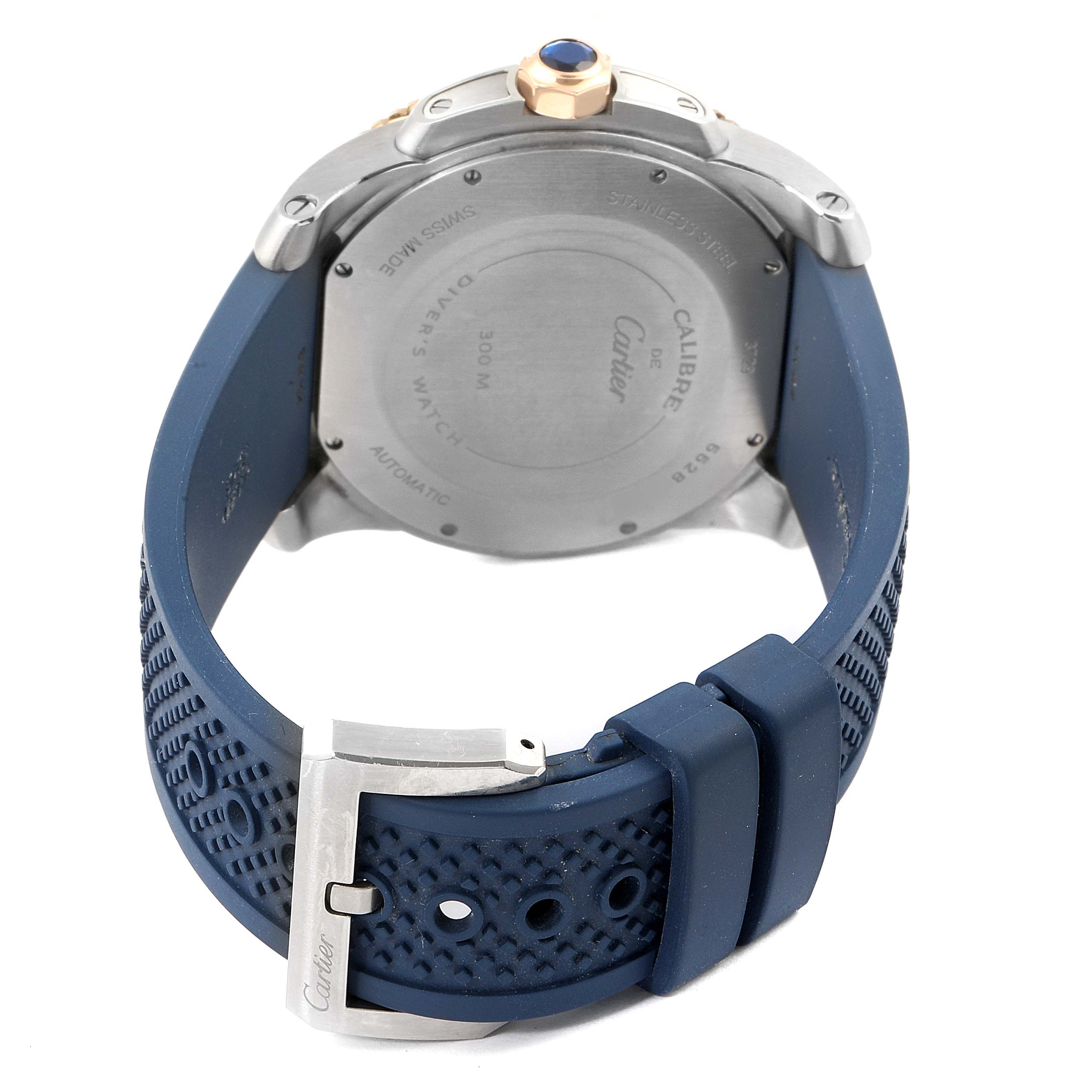 The image shows the back view of a Calibre de Cartier watch by Cartier, highlighting the case back, crown, and blue rubber strap with a buckle.