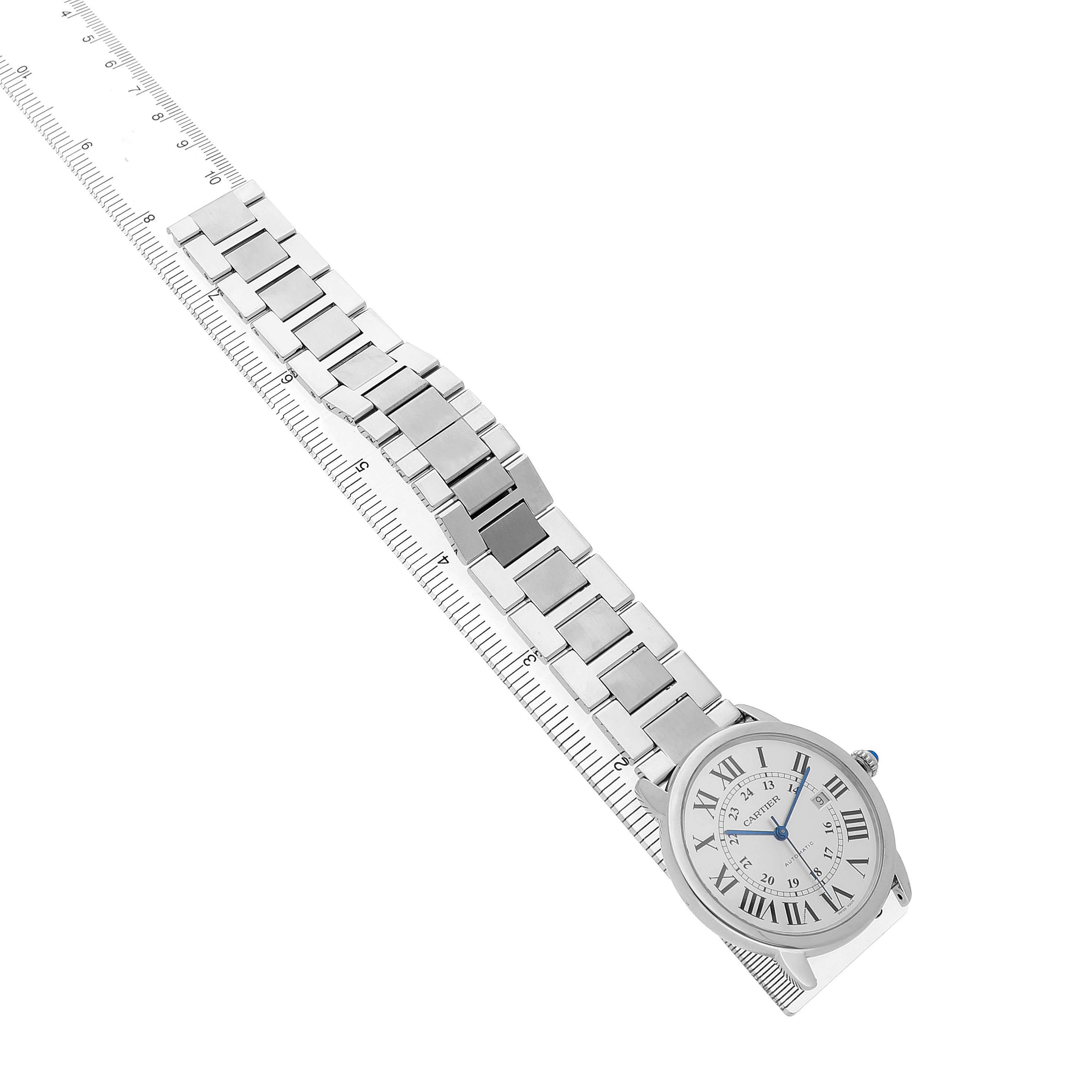 The Cartier Ronde W6701011 Men's Stainless Steel Silver Dial watch is shown from a top angle, displaying its face with Roman numerals and metallic bracelet alongside a ruler.