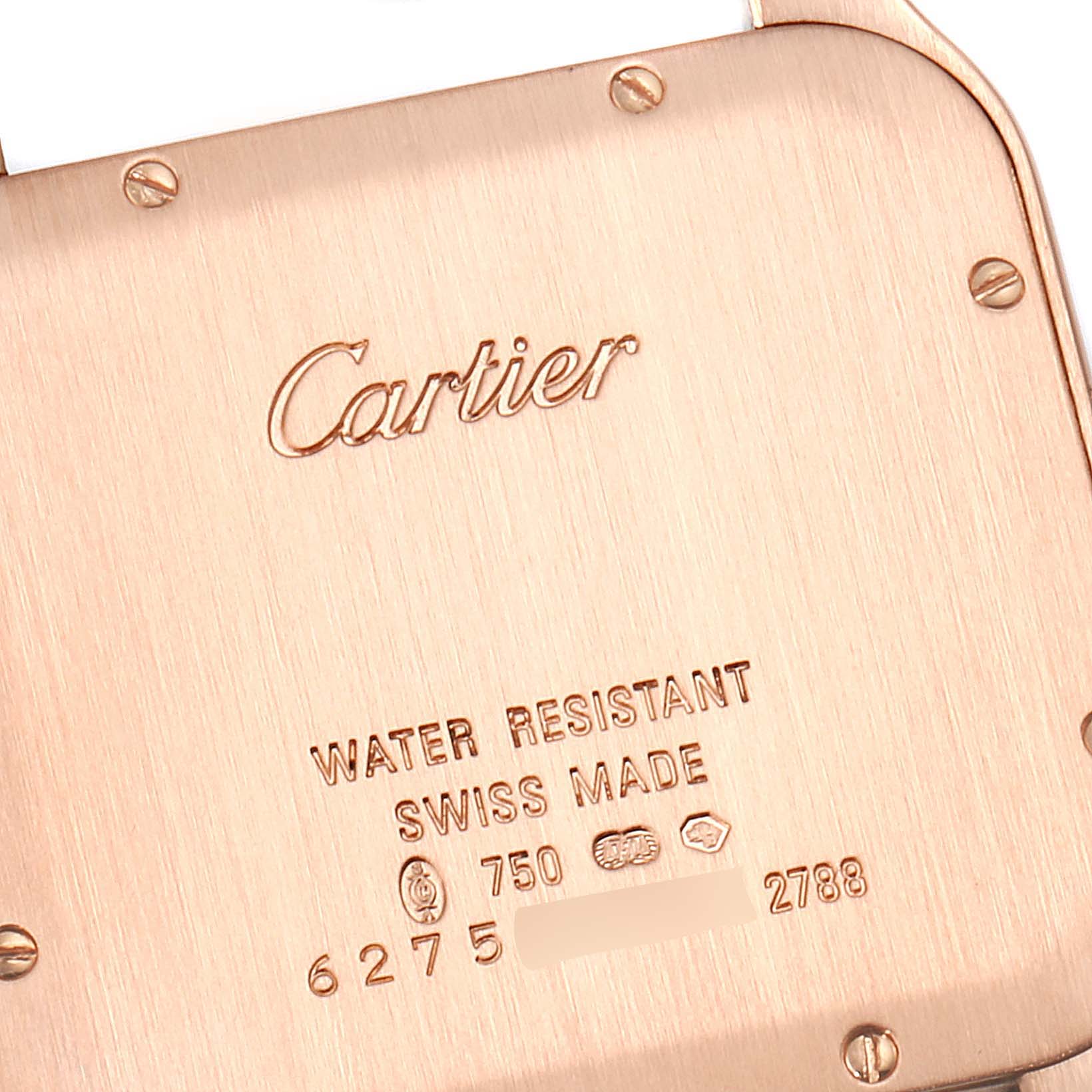 The image shows the back case of a Santos Dumont model watch by Cartier, with engravings of brand and specifications.