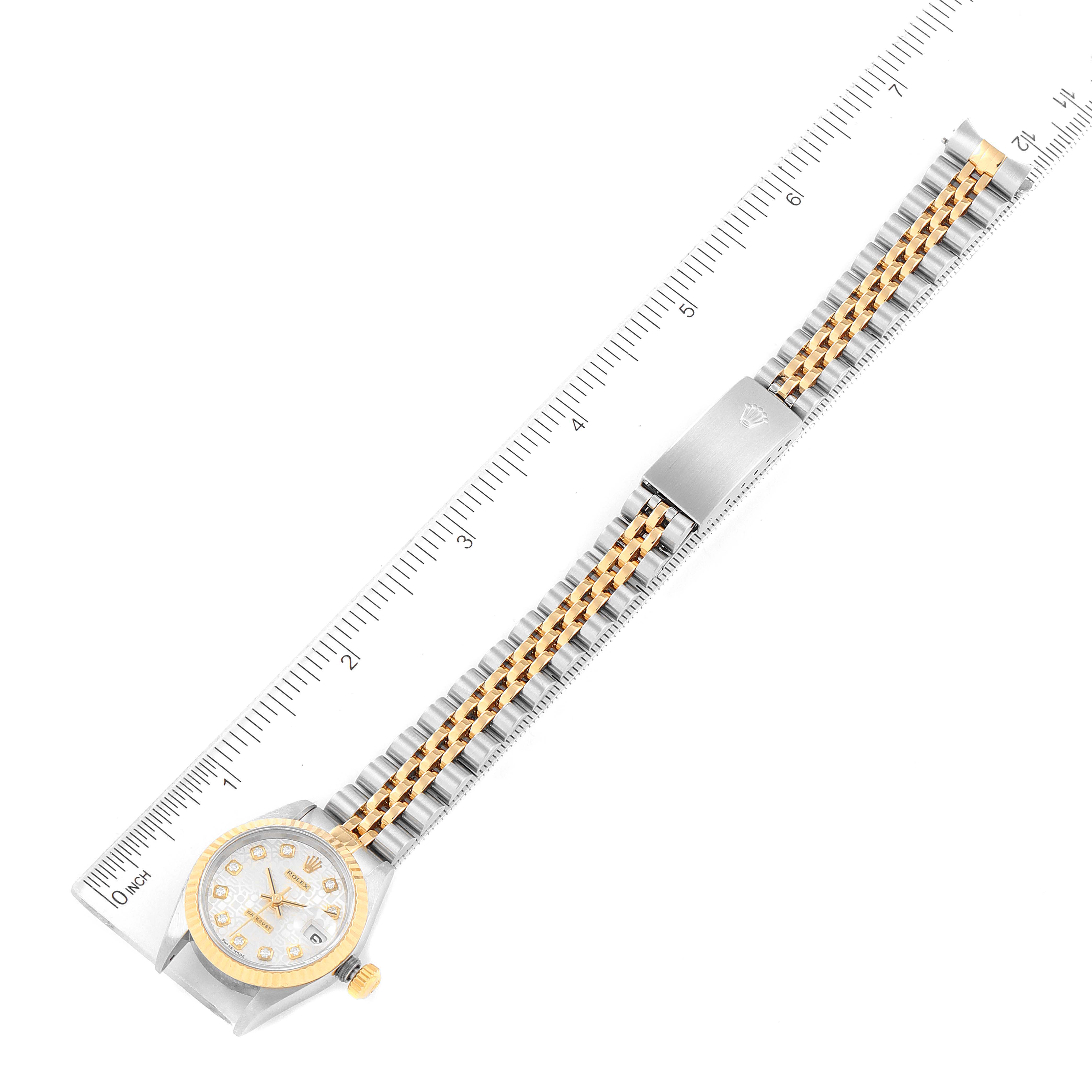 This image shows a Rolex Datejust 79173 Women
s Steel and Gold (two tone) Silver Dial 79173 Women
s Steel and Gold (two tone) Silver Dial watch fully extended with a ruler for scale and focusing on the bracelet and dial.