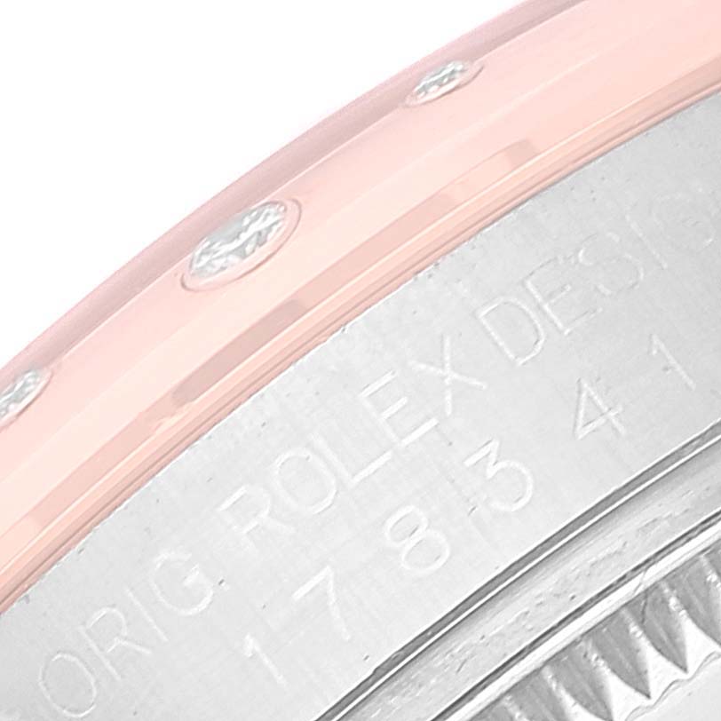 This close-up image of the Rolex Mid-Size 178341 Women's Steel and Gold (two tone) Brown Dial 178341 Women's Steel and Gold (two tone) Brown Dial model shows part of the bezel and the engraved text on the case.