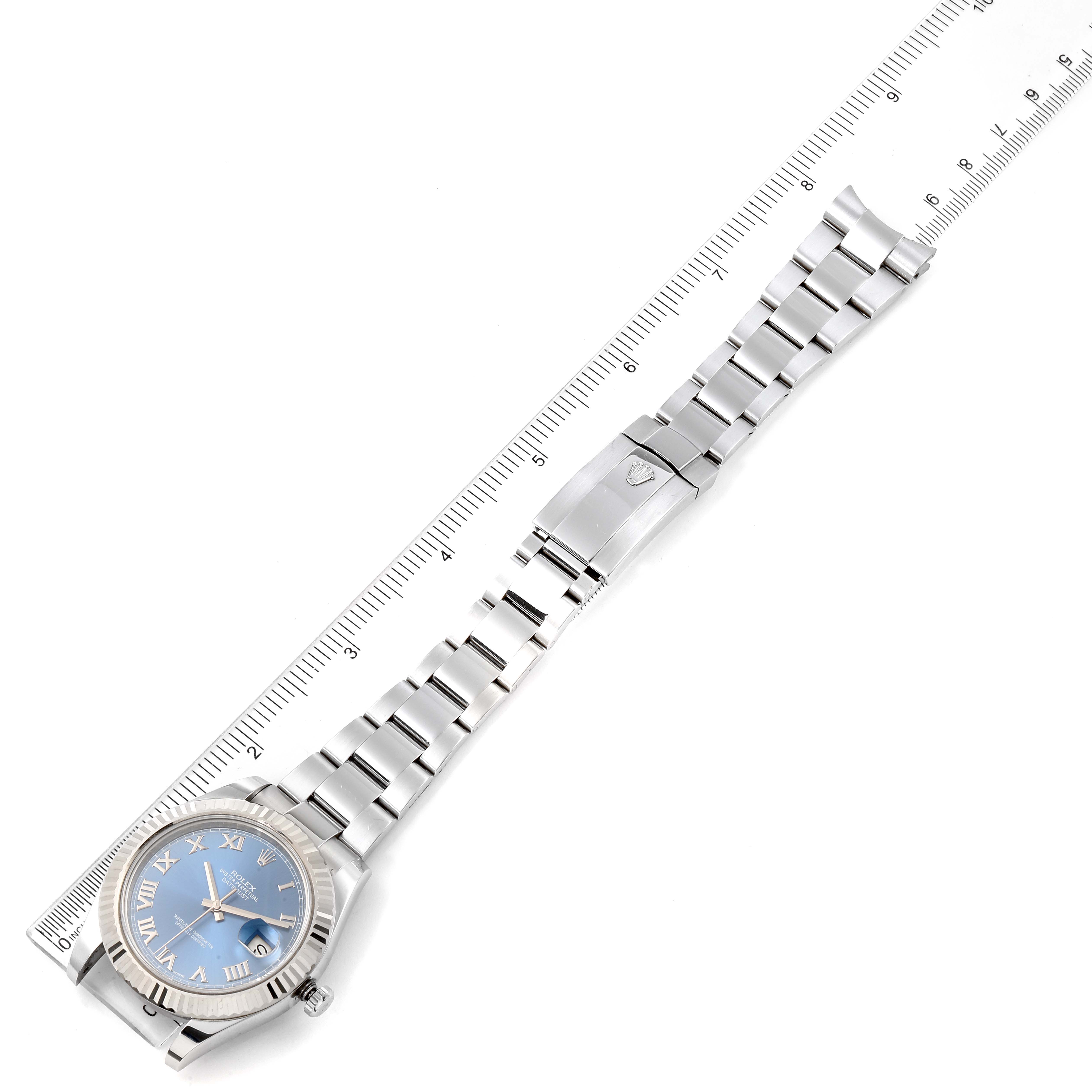 The Rolex Datejust 41 116334 Men's Stainless Steel Blue Dial 116334 Men's Stainless Steel Blue Dial watch is shown from above, highlighting its face, bracelet, and clasp alongside a measuring ruler.