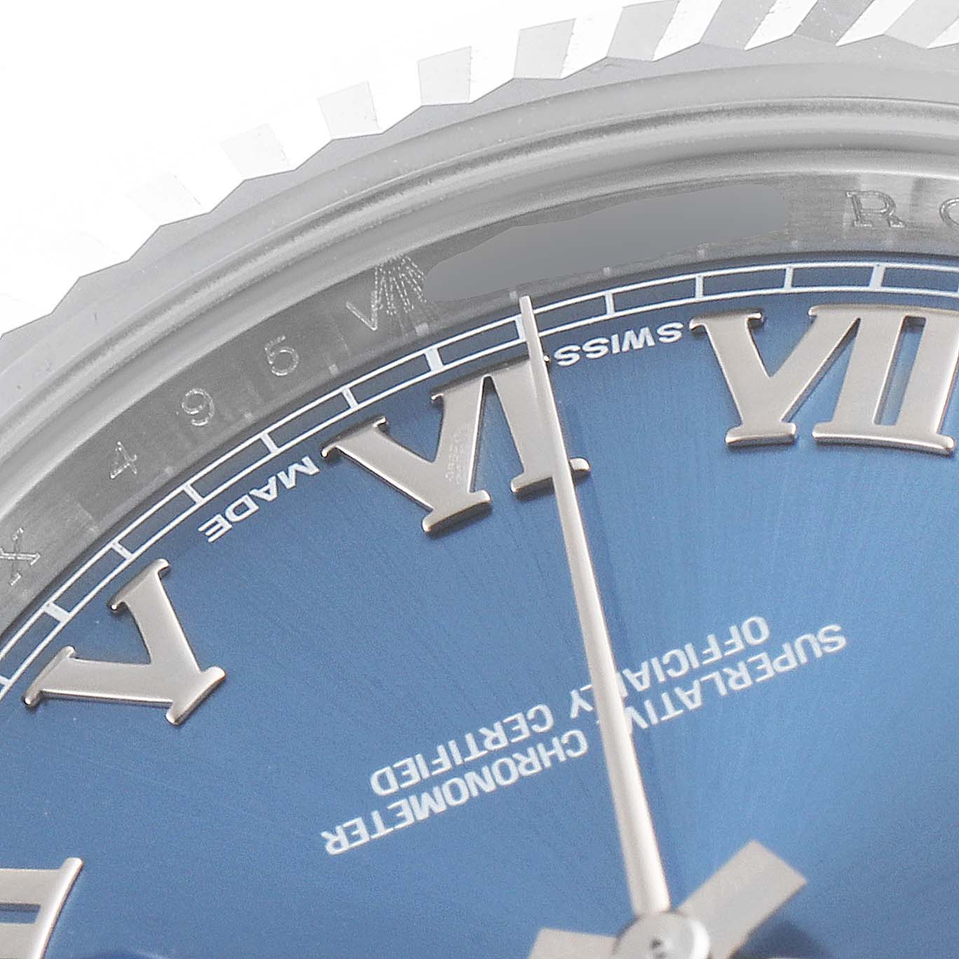This close-up image of the Rolex Datejust 41 116334 Men's Stainless Steel Blue Dial 116334 Men's Stainless Steel Blue Dial watch features a section of the blue dial, Roman numerals, and a portion of the fluted bezel.