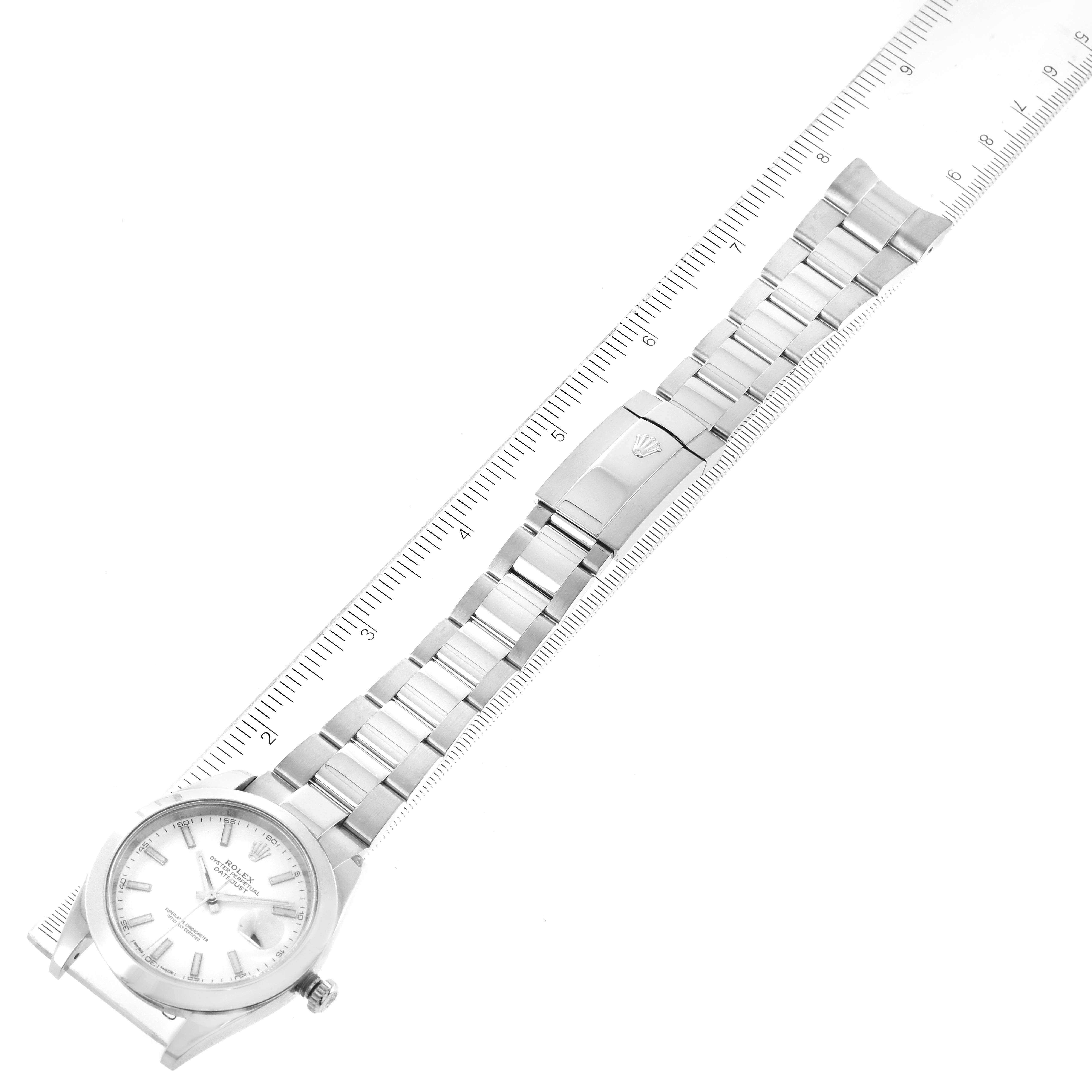 The Rolex Datejust 41 126300 Men
s Stainless Steel White Dial 126300 Men
s Stainless Steel White Dial watch is shown flatly from a top-down angle, featuring the face, bracelet, and clasp next to a ruler.