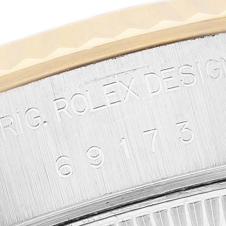 The image shows a close-up of the side of a Rolex Datejust 69173 Women's Steel and Gold (two tone) White Dial watch, highlighting the engraved model number and bezel edge.