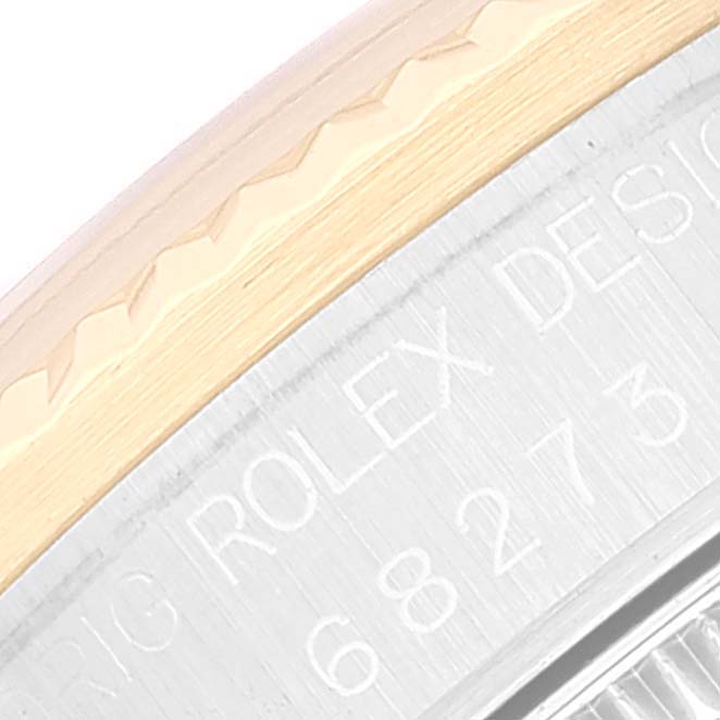 The image shows a close-up of the edge of the bezel and case back with engraved text on a Rolex Mid-Size 68273 Women
s Steel and Gold (two tone) White Dial 68273 Women
s Steel and Gold (two tone) White Dial model watch.