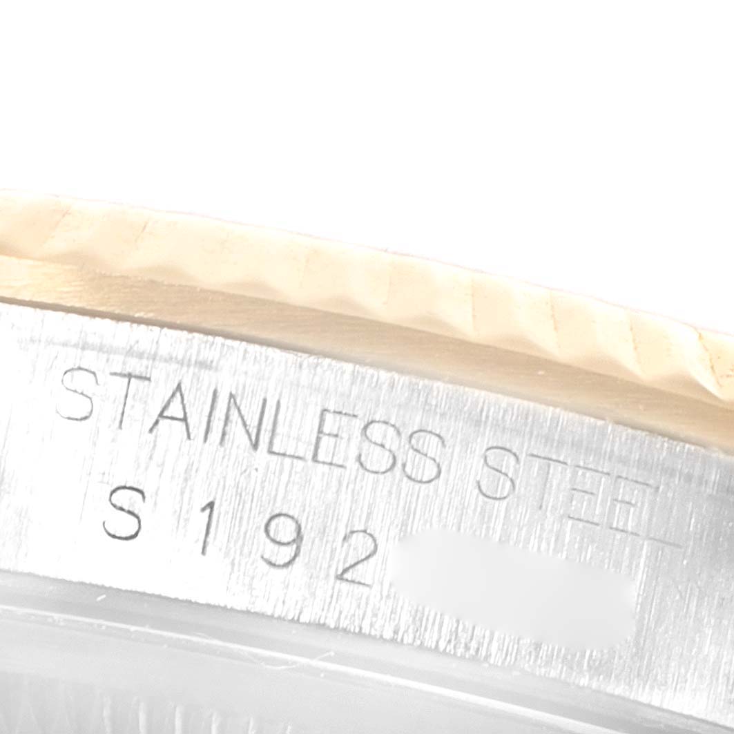 This close-up image of a Rolex Datejust 16233 Men's Steel and Gold (two tone) Champagne Dial 16233 Men's Steel and Gold (two tone) Champagne Dial watch shows the stainless steel case and part of the fluted bezel.