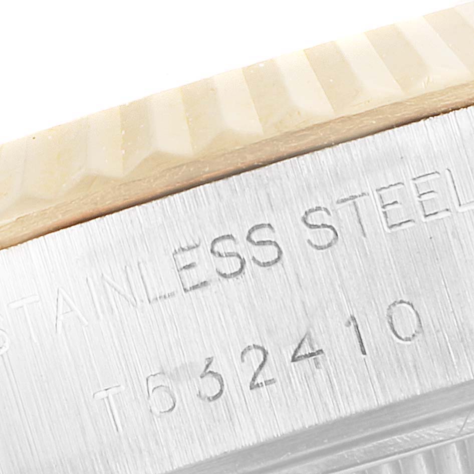 The image shows a close-up of the side of a Rolex Datejust 69173 Women's Steel and Gold (two tone) White Dial 69173 Women's Steel and Gold (two tone) White Dial watch, highlighting the fluted bezel and the engraved serial number.