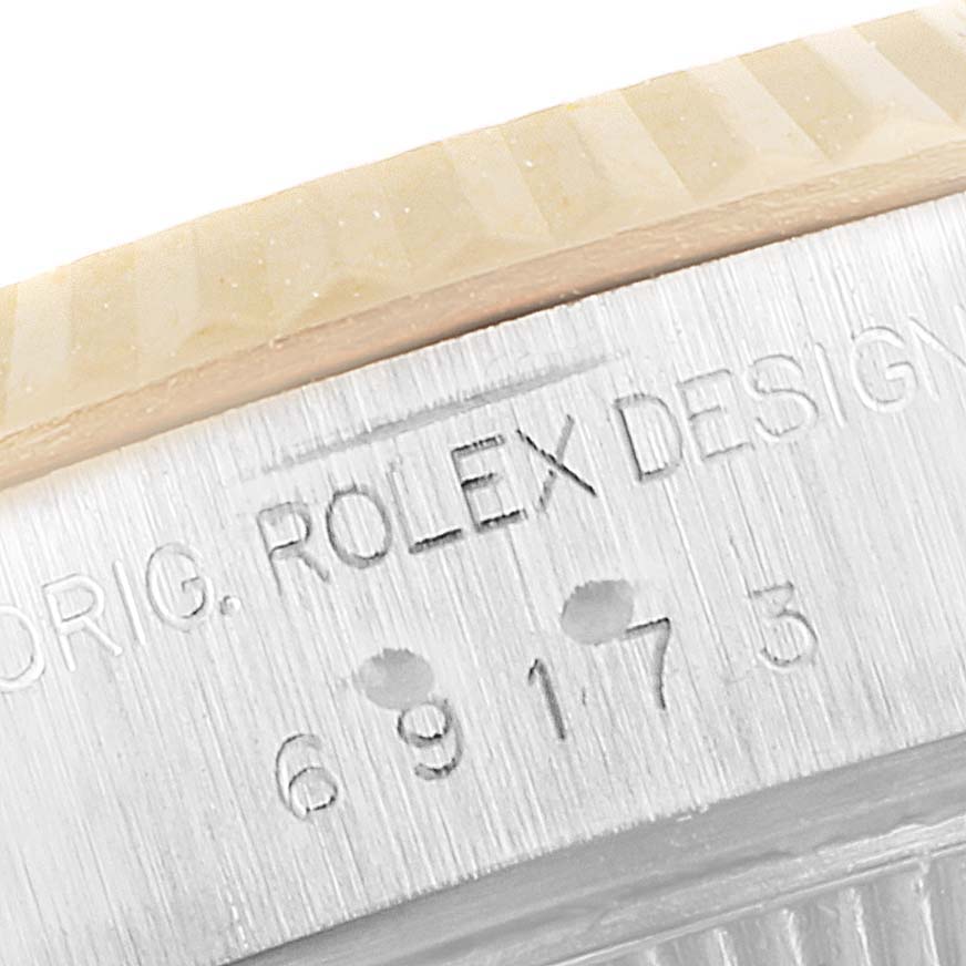 This close-up image shows the engraved side of the case of a Rolex Datejust 69173 Women's Steel and Gold (two tone) White Dial 69173 Women's Steel and Gold (two tone) White Dial watch, highlighting the model number.