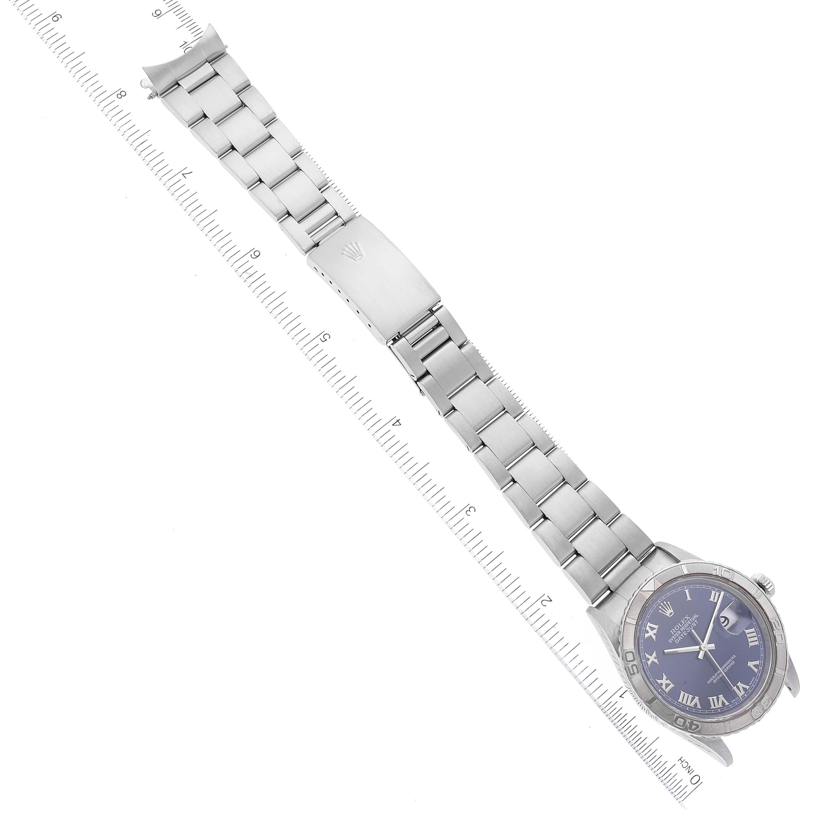 The image shows a full view of the Rolex Turn-o-Graph 16264 Men's Stainless Steel Blue Dial 16264 Men's Stainless Steel Blue Dial watch laid flat with a metal strap aligned with a ruler.