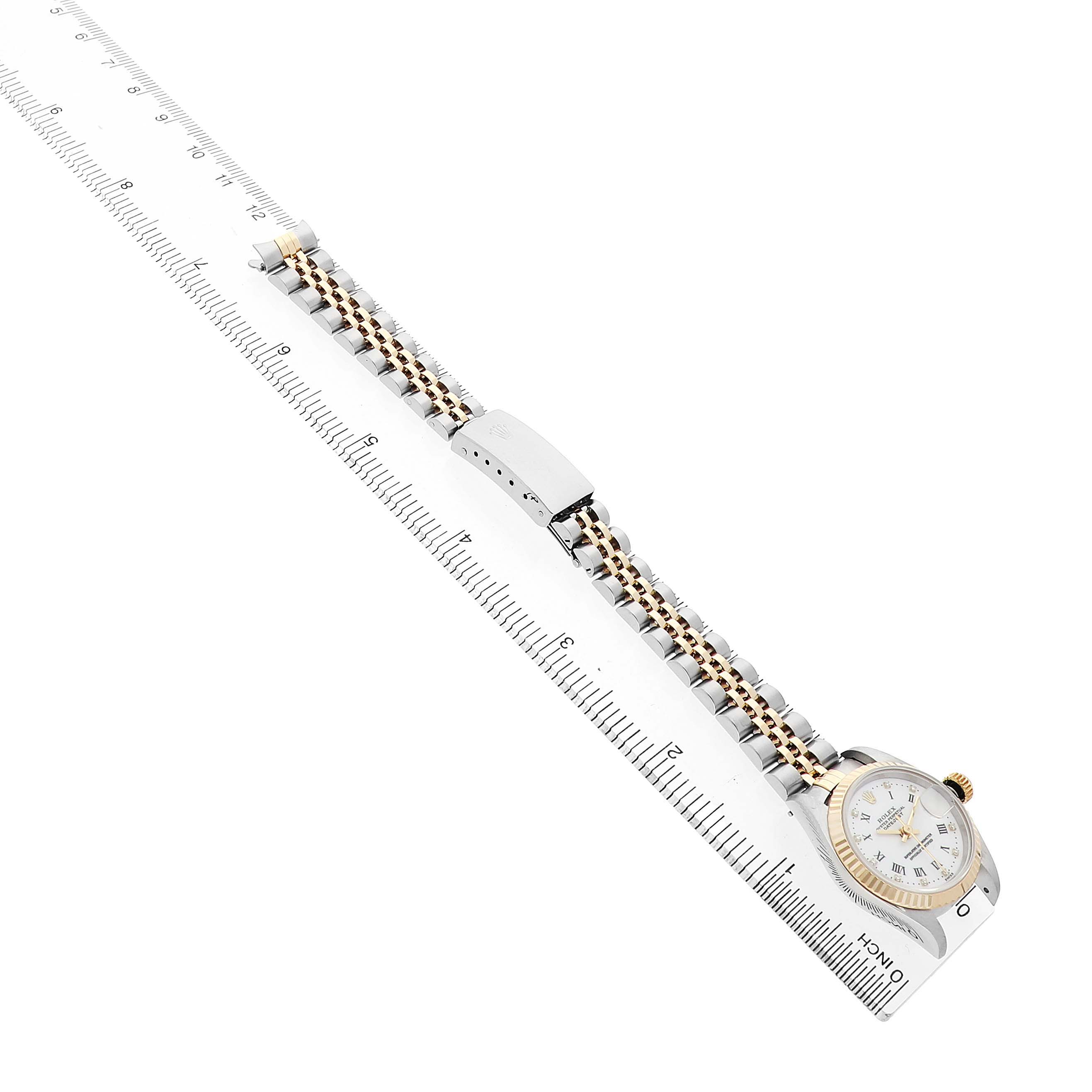 The image shows a Rolex Datejust 69173 Women's Steel and Gold (two tone) White Dial watch at an angle, displaying the face, bracelet, and clasp alongside a ruler for scale.