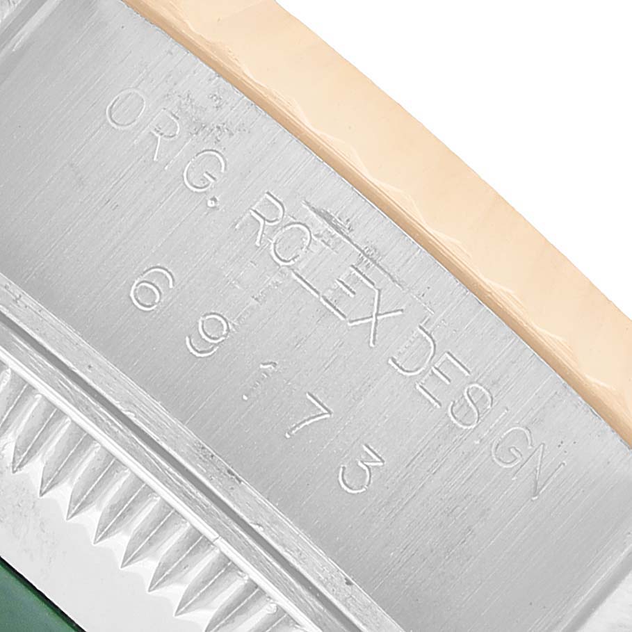 The image shows a close-up of the engraved wording on the side of a Rolex Datejust 69173 Women's Steel and Gold (two tone) White Dial, highlighting its unique design details.