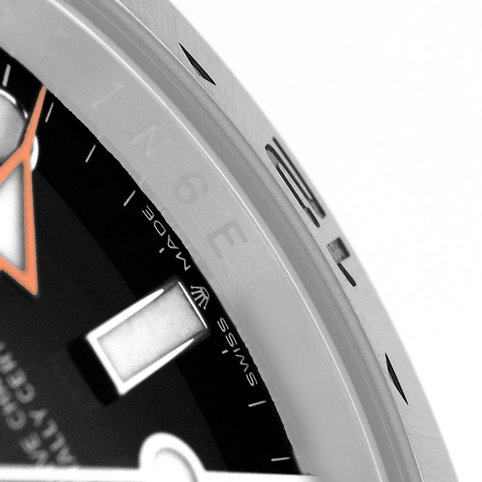 The image shows a close-up of the bezel, edge of the dial, and part of the hand of the Rolex Explorer 226570 Men's Stainless Steel Black Dial watch.