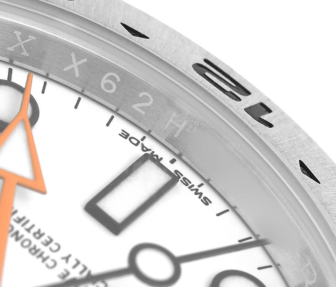 This close-up image of the Rolex Explorer 216570 Men's Stainless Steel White Dial watch shows the bezel, dial, and part of the orange hand.