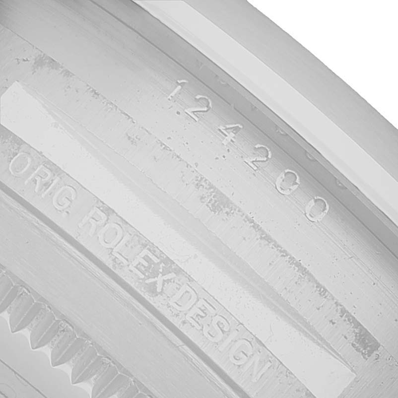 The image shows a close-up of the case side engraving on a Rolex Oyster Perpetual 124200 Men's Stainless Steel Blue Dial, highlighting the model number and design engraving.