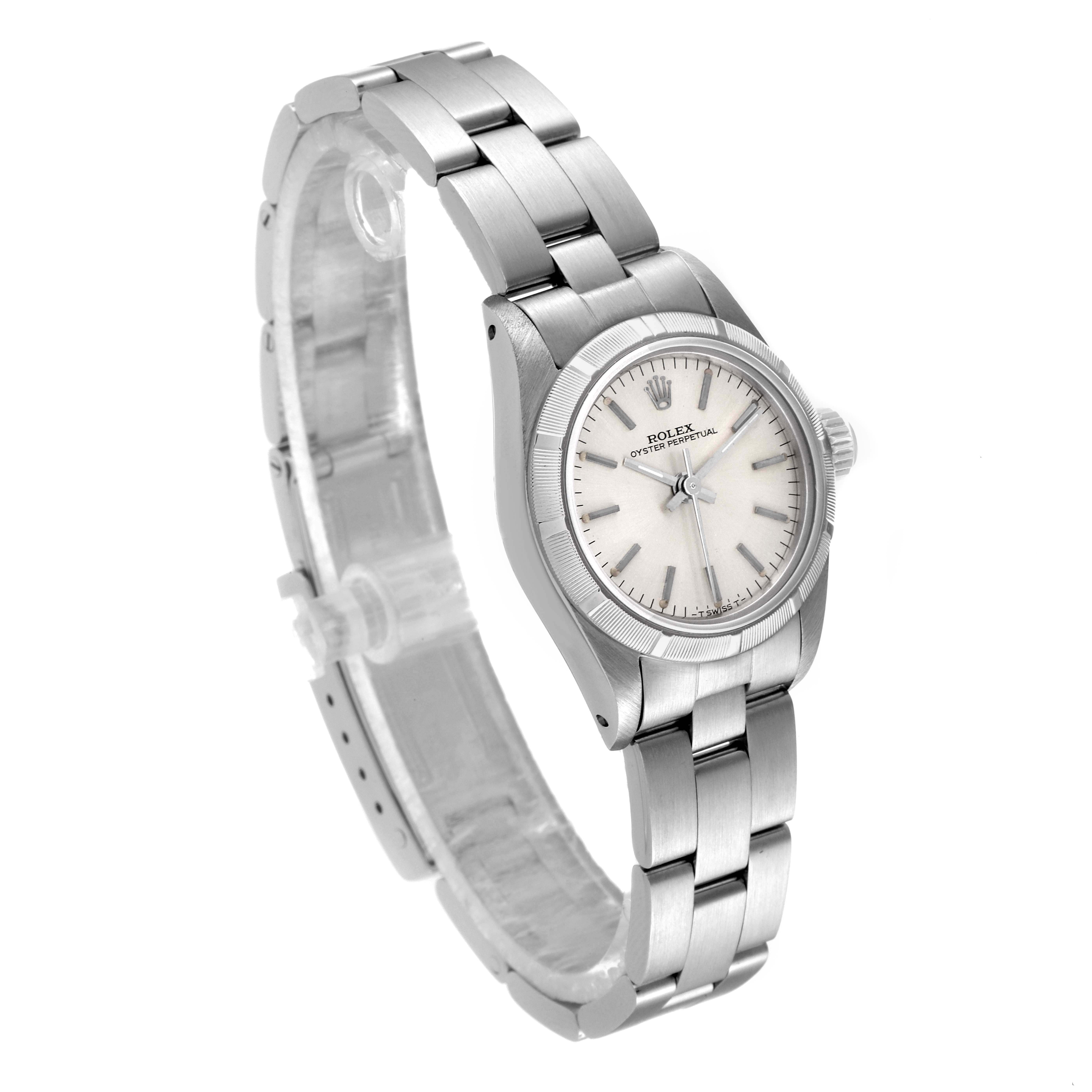 The image shows a side angle view of a Rolex Oyster Perpetual 67230 Women
s Stainless Steel Silver Dial 67230 Women
s Stainless Steel Silver Dial watch, highlighting the watch face, bracelet, and clasp.