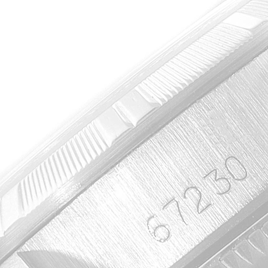 The image shows a close-up of the side of a Rolex Oyster Perpetual 67230 Women
s Stainless Steel Silver Dial 67230 Women
s Stainless Steel Silver Dial watch, highlighting the model number 67230 and parts of the bezel.
