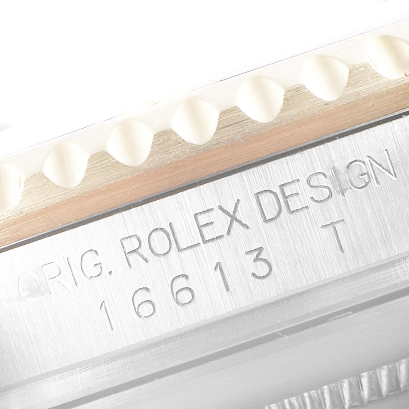 This image shows a close-up of the Rolex Submariner 16613 Men's Steel and Gold (two tone) Black Dial 16613 Men's Steel and Gold (two tone) Black Dial model's bezel edge and engraved serial number on the case.