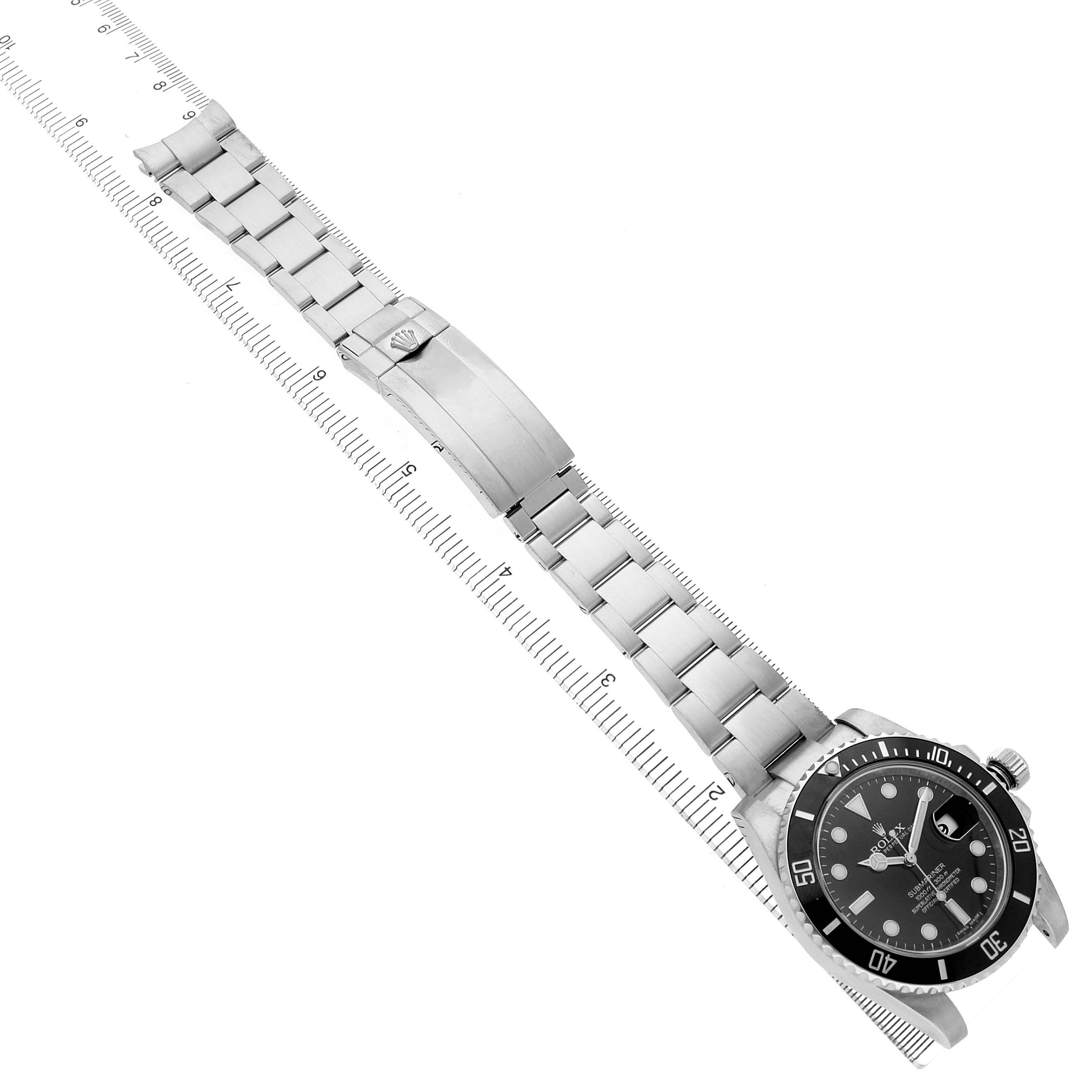 The Rolex Submariner 116610 Men's Stainless Steel Black Dial is shown from a top view, featuring the watch face, bezel, bracelet, and clasp alongside a ruler for scale.