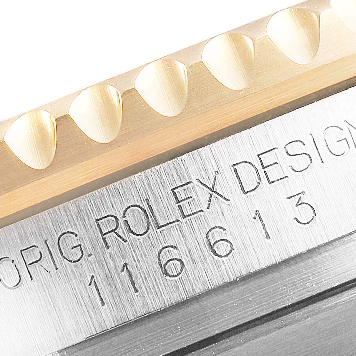 The image shows a close-up of the model number engraving and part of the bezel of a Rolex Submariner 116613 Men's Steel and Gold (two tone) Black Dial 116613 Men's Steel and Gold (two tone) Black Dial watch.