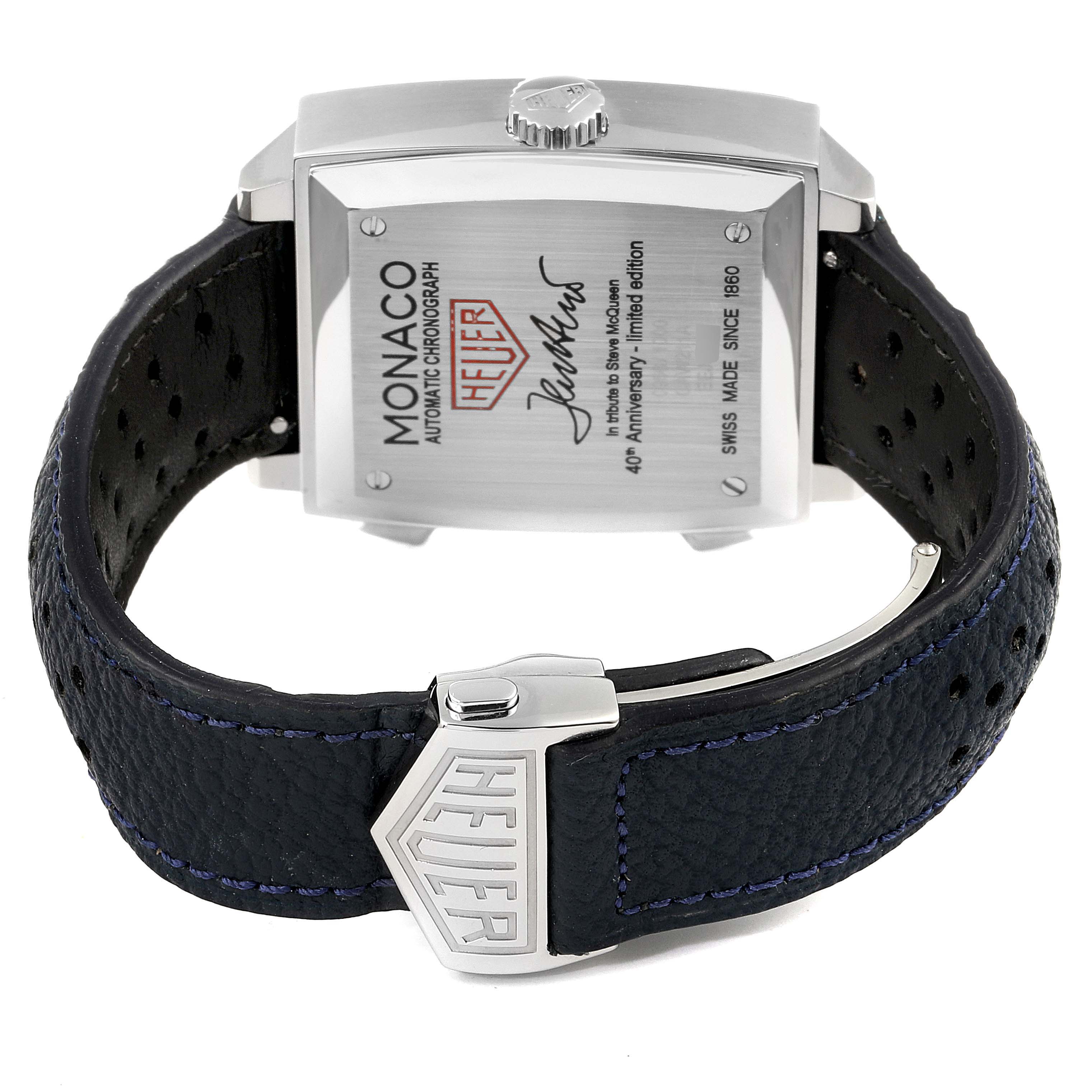 The image shows the back of the Tag Heuer Monaco watch with its black leather strap and Heuer-branded clasp.