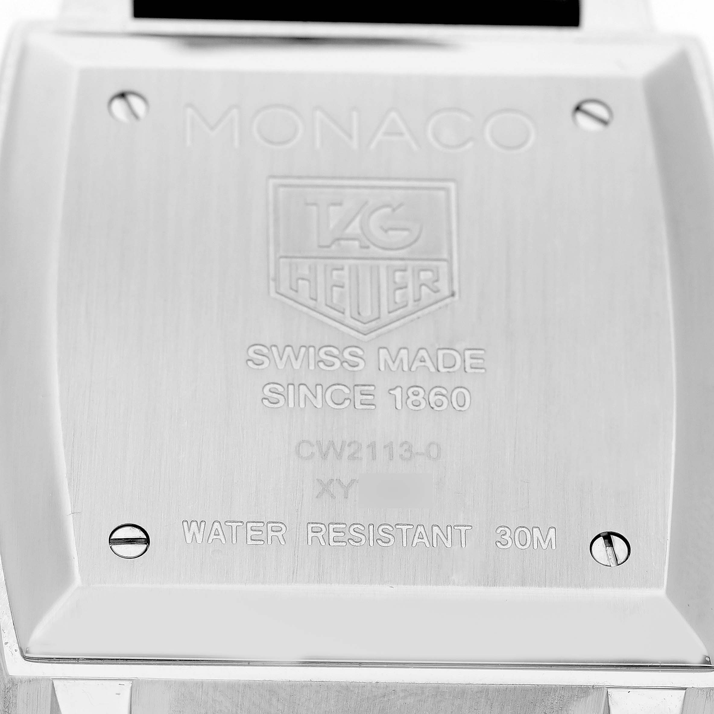 The image shows the back casing of a Tag Heuer Monaco CW2113 Men's Stainless Steel Blue Dial watch, displaying engraved details and screws.