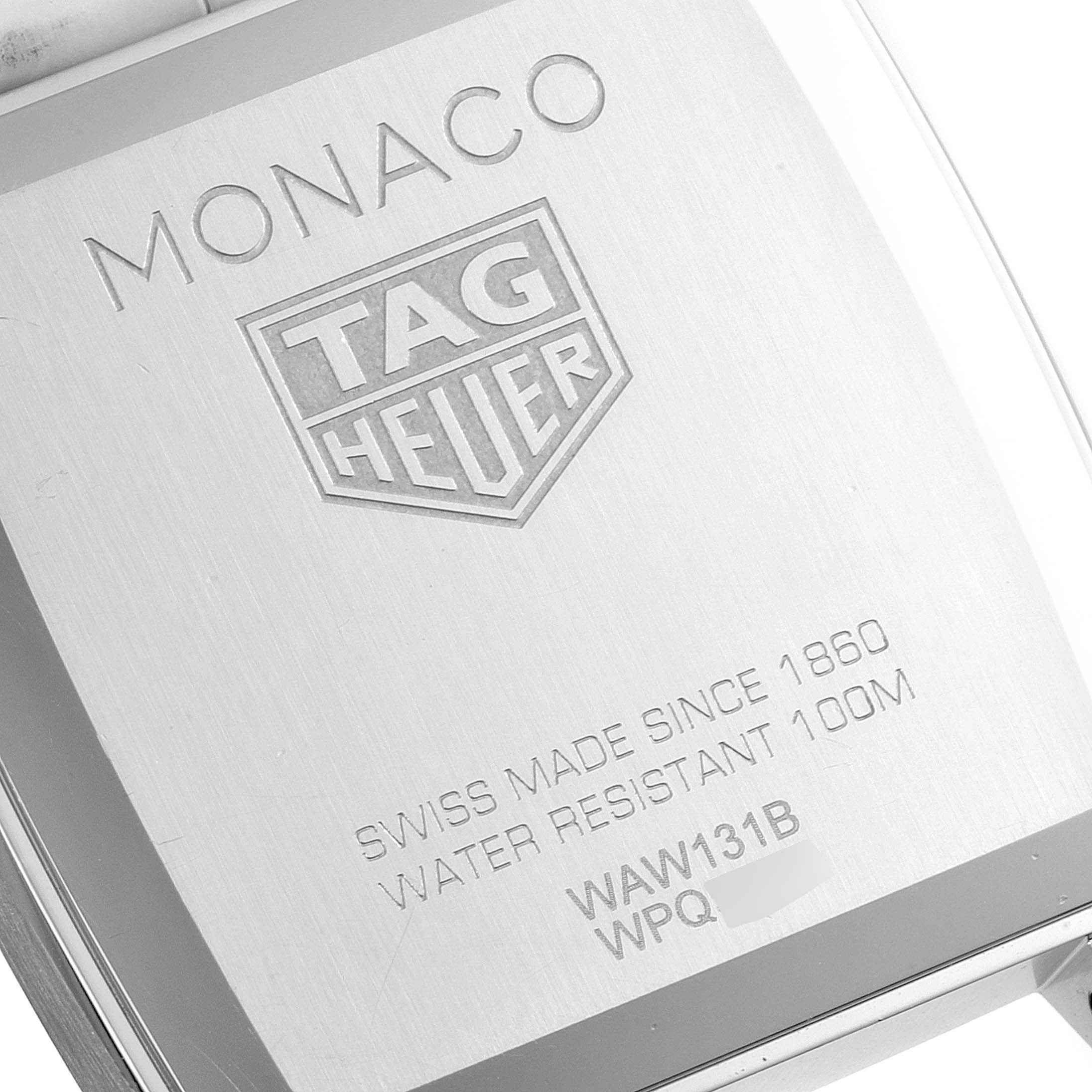 The image shows the back case of a Tag Heuer Monaco WAW131B.FC6247 Women's Stainless Steel Mother of Pearl Dial WAW131B.FC6247 Women's Stainless Steel Mother of Pearl Dial watch at a slight angle, highlighting the brand logo and model details.