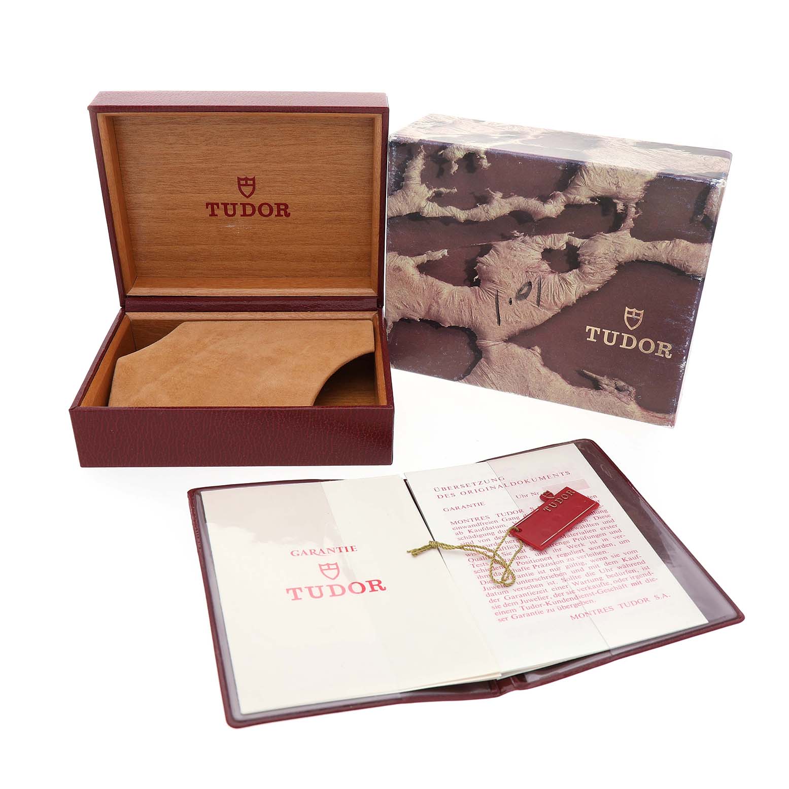The Tudor Prince 74000 Men's Stainless Steel Silver Dial watch accessories include an open wooden box, outer box, guarantee booklet, and tag, shown at a frontal angle.