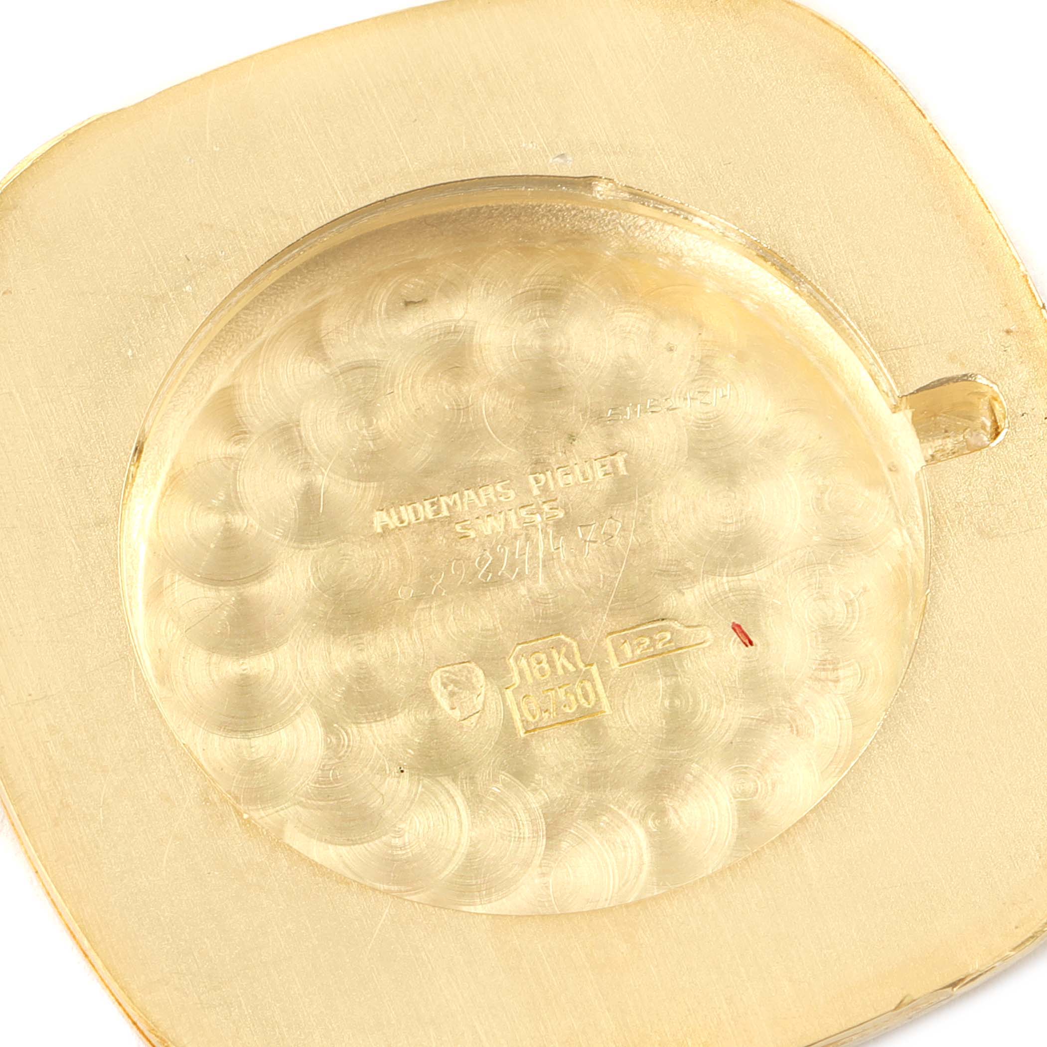 The image shows the back case of a Vintage Audemars Piguet watch, highlighting inscriptions and the 18K gold mark.
