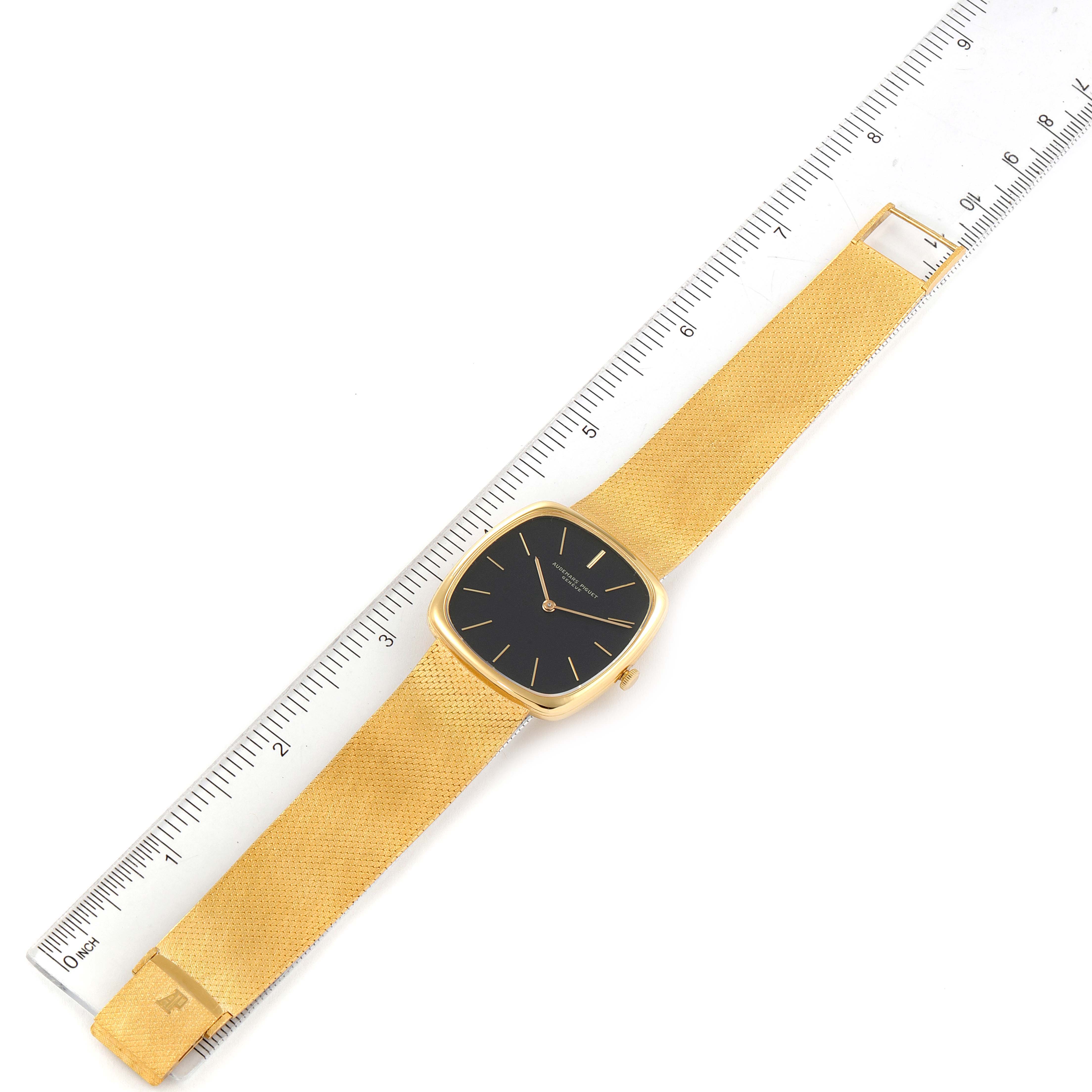 The image shows a top-down view of a Vintage Audemars Piguet watch with a gold band and black face, alongside a ruler.