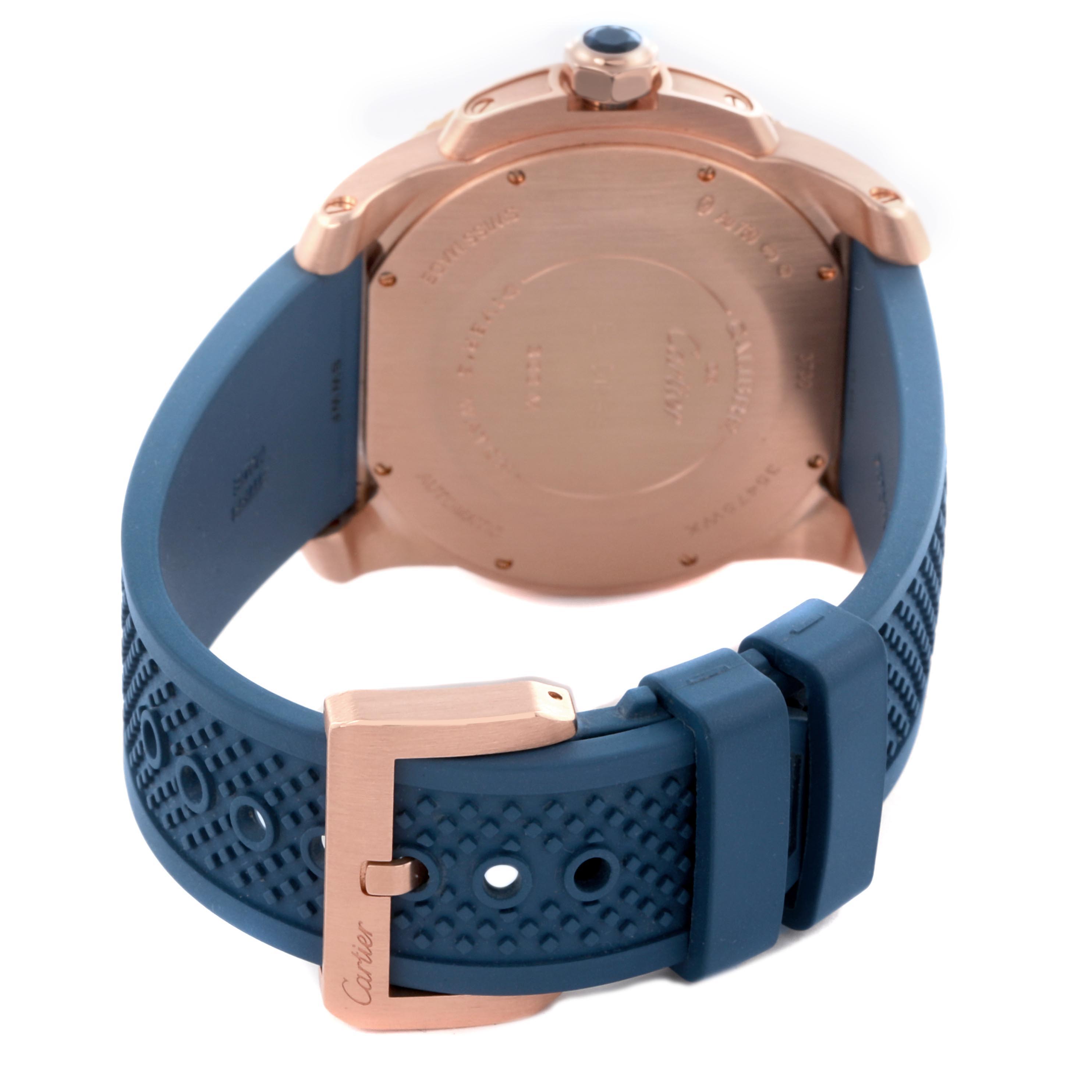 The image shows the back of a Calibre de Cartier watch with its blue strap and rose gold buckle.
