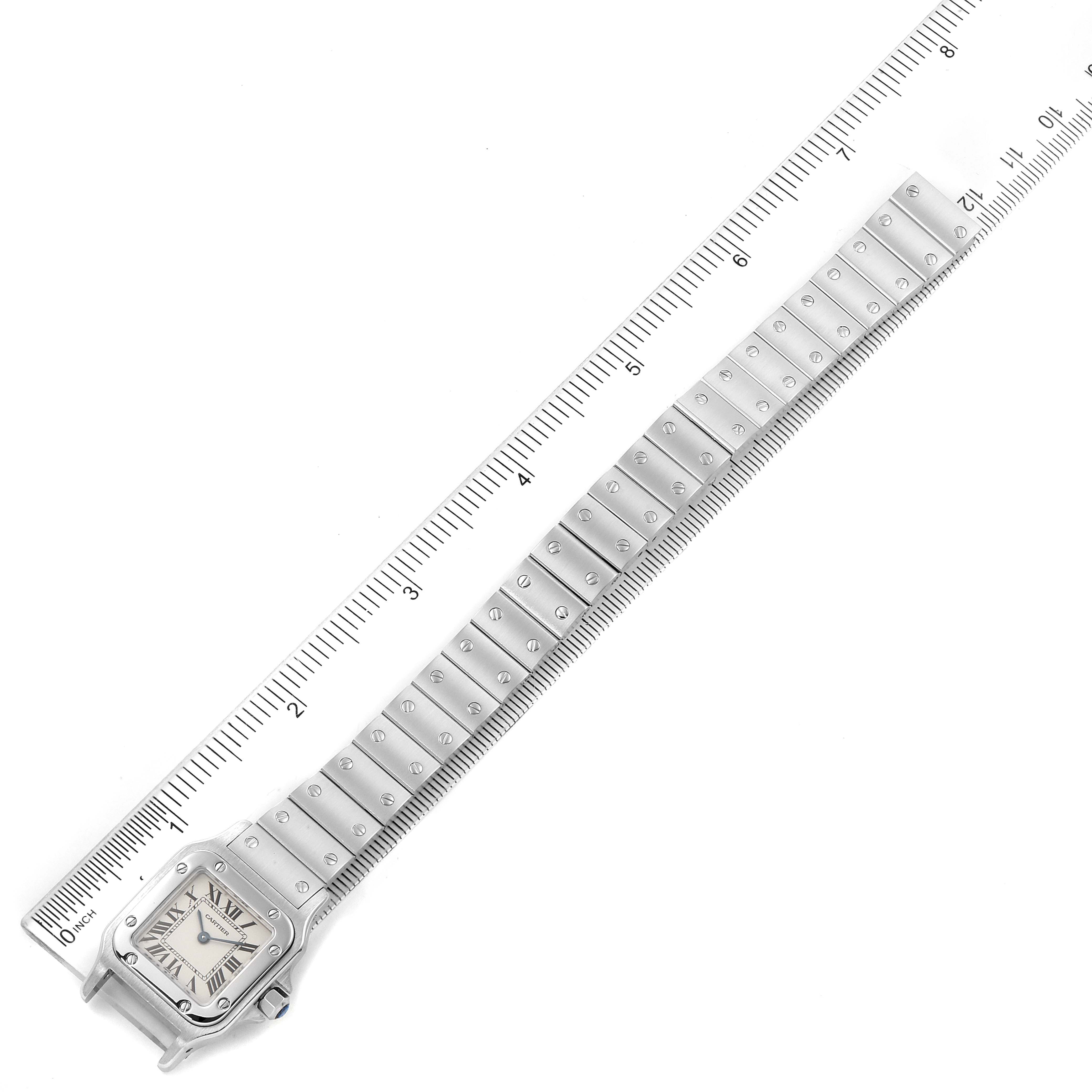 The image shows a Cartier Santos W20056D6 Women's Stainless Steel Silver Dial W20056D6 Women's Stainless Steel Silver Dial watch at an angle that captures the full length of the bracelet alongside a ruler for scale.