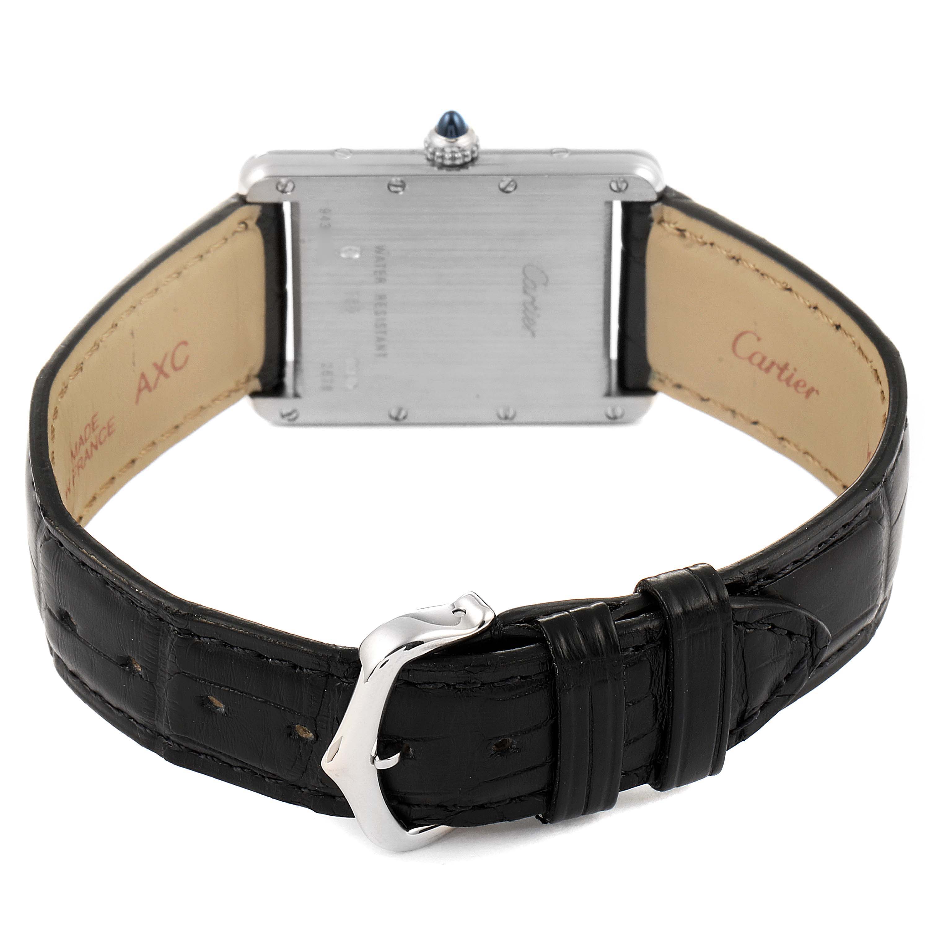 The image shows the back of a Tank Louis Cartier watch, including the case back, leather strap, and buckle.