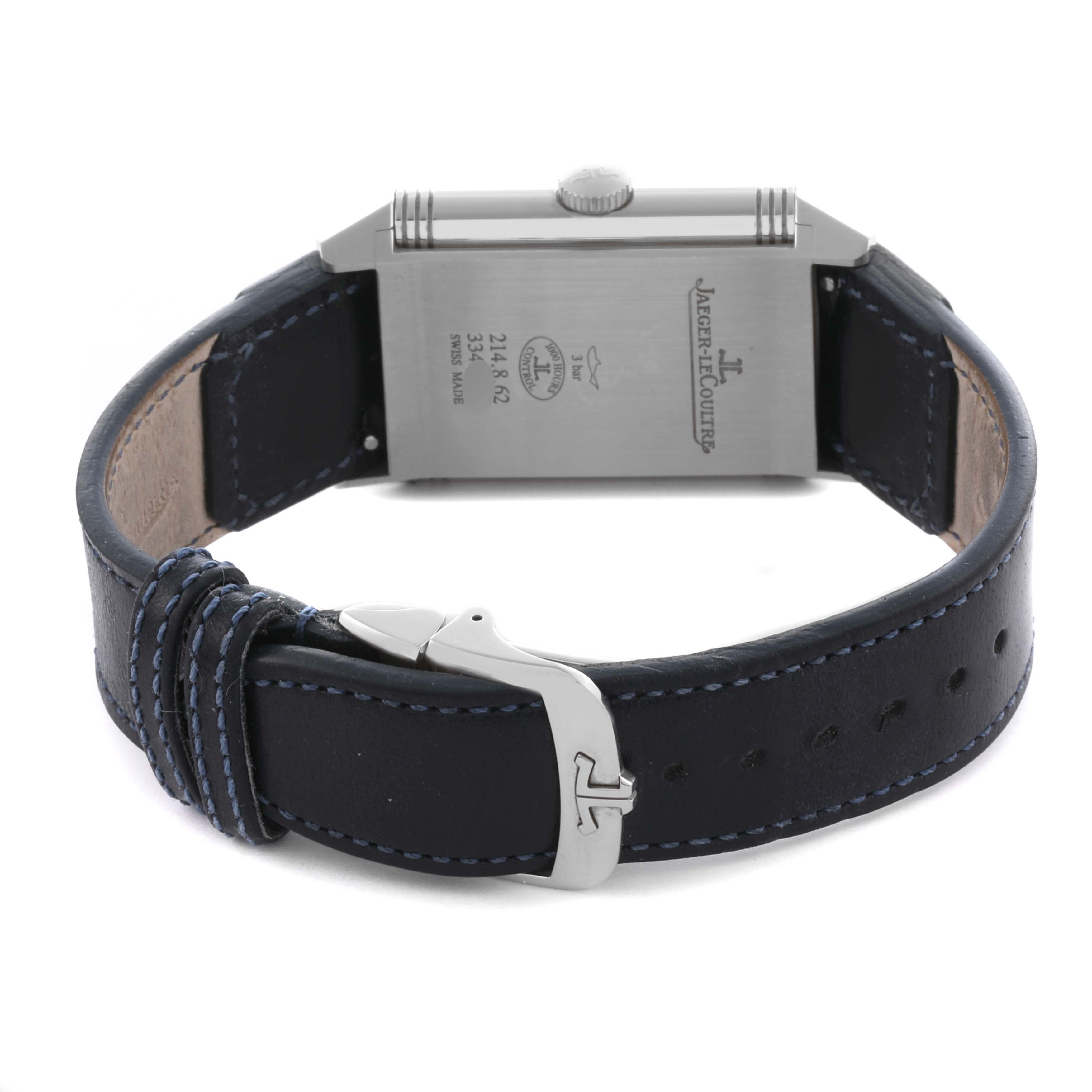 The Jaeger-LeCoultre Reverso watch is shown from the back, displaying the case, crown, and leather strap with a clasp.